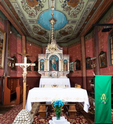 Zdjęcie nr 19: Kościół parafialny w Gruszowie znajduje się na niewielkim wzniesieniu w centrum miejscowości. Budowla jest orientowana, jednonawowa, z szerokim zamkniętym trójbocznie prezbiterium oraz czworoboczną wieżą od zachodu. Korpusu nawowy i prezbiterium charakteryzuje konstrukcja zrębowa, natomiast wieżę słupowa. Od północy do prezbiterium przylega zakrystia na rzucie prostokąta, natomiast do nawy zamknięta trójbocznie kaplica boczna. Do wnętrza kościoła prowadzą dwie kruchty, jedna od strony południowej, druga przez wieżę od zachodniej. Nad korpusem nawowym i prezbiterium znajduje się jednokalenicowy dach kryty gontem, a na styku nawy i prezbiterium usytuowana jest drewniana wieżyczka na sygnaturkę nakryta baniastym hełmem z latarnią. Zakrystia przekryta jest dachem pulpitowym, natomiast kaplica boczna oraz kruchty dachami dwuspadowymi krytymi gontem. Izbicową, o pochyłych ścianach wieżę wieńczy okuty blachą dach namiotowy. Elewacje osłania szalunek z pionowych desek z tzw. listwowaniem oraz pseudopilastry, dodatkowo wieżę w jednej trzeciej wysokości obiega niewielki parapet kryty gontem. W strukturze korpusu nawowego otwory okienne znajdują się po stronie południowej i mają kształt stojących prostokątów. W prezbiterium znajduje się po jednym oknie od południa i od wschodu, ich prostokątna forma jest zamknięta łukiem w ośli grzbiet. W kaplicy bocznej jest jedno okno od strony zachodniej. Ściana wschodnia zakrystii przepruta jest dwoma niewielkimi oknami, natomiast kruchty południowej jednym. W kruchcie zachodniej od południa jest jedno okno, natomiast w dolnej partii wieży znajdują się trzy, z czego dwa dolne oddziela od górnego niewielki daszek pulpitowy. Wnętrze korpusu nawowego i prezbiterium kościoła nakryte jest drewnianym stropem. Do kaplicy bocznej prowadzi szerokie przejście o ostrołukowym wykroju. Południowy portal w korpusie nawowym wieńczy wykrój w formie łuku w ośli grzbiet. Ściany i stropy wnętrza kościoła pokrywa secesyjna polichromia. 
Plac przykościelny otoczony jest drewnianym ogrodzeniem oraz starodrzewem.
