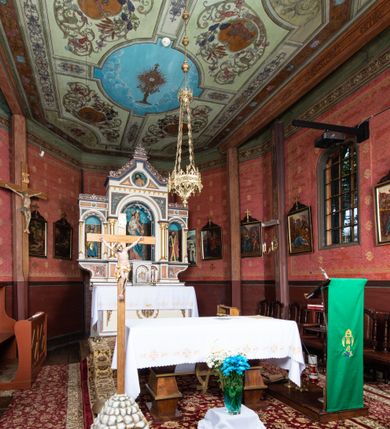 Zdjęcie nr 20: Kościół parafialny w Gruszowie znajduje się na niewielkim wzniesieniu w centrum miejscowości. Budowla jest orientowana, jednonawowa, z szerokim zamkniętym trójbocznie prezbiterium oraz czworoboczną wieżą od zachodu. Korpusu nawowy i prezbiterium charakteryzuje konstrukcja zrębowa, natomiast wieżę słupowa. Od północy do prezbiterium przylega zakrystia na rzucie prostokąta, natomiast do nawy zamknięta trójbocznie kaplica boczna. Do wnętrza kościoła prowadzą dwie kruchty, jedna od strony południowej, druga przez wieżę od zachodniej. Nad korpusem nawowym i prezbiterium znajduje się jednokalenicowy dach kryty gontem, a na styku nawy i prezbiterium usytuowana jest drewniana wieżyczka na sygnaturkę nakryta baniastym hełmem z latarnią. Zakrystia przekryta jest dachem pulpitowym, natomiast kaplica boczna oraz kruchty dachami dwuspadowymi krytymi gontem. Izbicową, o pochyłych ścianach wieżę wieńczy okuty blachą dach namiotowy. Elewacje osłania szalunek z pionowych desek z tzw. listwowaniem oraz pseudopilastry, dodatkowo wieżę w jednej trzeciej wysokości obiega niewielki parapet kryty gontem. W strukturze korpusu nawowego otwory okienne znajdują się po stronie południowej i mają kształt stojących prostokątów. W prezbiterium znajduje się po jednym oknie od południa i od wschodu, ich prostokątna forma jest zamknięta łukiem w ośli grzbiet. W kaplicy bocznej jest jedno okno od strony zachodniej. Ściana wschodnia zakrystii przepruta jest dwoma niewielkimi oknami, natomiast kruchty południowej jednym. W kruchcie zachodniej od południa jest jedno okno, natomiast w dolnej partii wieży znajdują się trzy, z czego dwa dolne oddziela od górnego niewielki daszek pulpitowy. Wnętrze korpusu nawowego i prezbiterium kościoła nakryte jest drewnianym stropem. Do kaplicy bocznej prowadzi szerokie przejście o ostrołukowym wykroju. Południowy portal w korpusie nawowym wieńczy wykrój w formie łuku w ośli grzbiet. Ściany i stropy wnętrza kościoła pokrywa secesyjna polichromia. 
Plac przykościelny otoczony jest drewnianym ogrodzeniem oraz starodrzewem.
