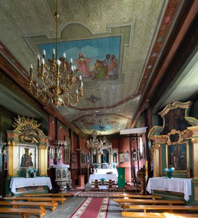 Zdjęcie nr 16: Kościół parafialny w Gruszowie znajduje się na niewielkim wzniesieniu w centrum miejscowości. Budowla jest orientowana, jednonawowa, z szerokim zamkniętym trójbocznie prezbiterium oraz czworoboczną wieżą od zachodu. Korpusu nawowy i prezbiterium charakteryzuje konstrukcja zrębowa, natomiast wieżę słupowa. Od północy do prezbiterium przylega zakrystia na rzucie prostokąta, natomiast do nawy zamknięta trójbocznie kaplica boczna. Do wnętrza kościoła prowadzą dwie kruchty, jedna od strony południowej, druga przez wieżę od zachodniej. Nad korpusem nawowym i prezbiterium znajduje się jednokalenicowy dach kryty gontem, a na styku nawy i prezbiterium usytuowana jest drewniana wieżyczka na sygnaturkę nakryta baniastym hełmem z latarnią. Zakrystia przekryta jest dachem pulpitowym, natomiast kaplica boczna oraz kruchty dachami dwuspadowymi krytymi gontem. Izbicową, o pochyłych ścianach wieżę wieńczy okuty blachą dach namiotowy. Elewacje osłania szalunek z pionowych desek z tzw. listwowaniem oraz pseudopilastry, dodatkowo wieżę w jednej trzeciej wysokości obiega niewielki parapet kryty gontem. W strukturze korpusu nawowego otwory okienne znajdują się po stronie południowej i mają kształt stojących prostokątów. W prezbiterium znajduje się po jednym oknie od południa i od wschodu, ich prostokątna forma jest zamknięta łukiem w ośli grzbiet. W kaplicy bocznej jest jedno okno od strony zachodniej. Ściana wschodnia zakrystii przepruta jest dwoma niewielkimi oknami, natomiast kruchty południowej jednym. W kruchcie zachodniej od południa jest jedno okno, natomiast w dolnej partii wieży znajdują się trzy, z czego dwa dolne oddziela od górnego niewielki daszek pulpitowy. Wnętrze korpusu nawowego i prezbiterium kościoła nakryte jest drewnianym stropem. Do kaplicy bocznej prowadzi szerokie przejście o ostrołukowym wykroju. Południowy portal w korpusie nawowym wieńczy wykrój w formie łuku w ośli grzbiet. Ściany i stropy wnętrza kościoła pokrywa secesyjna polichromia. 
Plac przykościelny otoczony jest drewnianym ogrodzeniem oraz starodrzewem.
