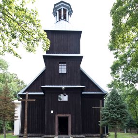 Zdjęcie nr 1: Kościół pw. św. Wawrzyńca w Grojcu jest drewnianą budowlą orientowaną, jednonawową z trójbocznie zamkniętym węższym prezbiterium od wschodu i wieżą od zachodu. Prostokątna nawa została wzniesiona na zrąb. Nawę i prezbiterium przykrywa dach siodłowy pokryty blachą cynkowaną. Do prezbiterium od północy przylega murowana zakrystia na rzucie prostokąta nakryta blaszanym dachem pulpitowym, a od południa prostokątny, drewniany aneks pełniący funkcję kaplicy bocznej, o podobnym dachu. Od północy do nawy dostawiono murowaną kaplicę na rzucie prostokąta przylegającą do zakrystii, a od południa niewielką czworoboczną kruchtę. Obie przestrzenie przykryto blaszanym dachem pulpitowym. W kruchcie południowej znajduje się drewniany portal z nadprożem w wykroju w ośli grzbiet. Nad wschodnią częścią nawy usytuowano sygnaturkę w kształcie wielobocznej latarni z krzyżem. Od zachodu do nawy dostawiono czworoboczną, drewnianą wieżę wzniesioną w konstrukcji słupowej, która w połowie nad nawą jest nadwieszona. Jej ściany są pionowe podzielone daszkami na trzy kondygnacje. Nakrywa ją blaszany, namiotowy hełm z latarnią zwieńczoną krzyżem. W przyziemiu wieży urządzono kruchtę. Wnętrze kościoła nakryto stropem z fasetą oddzieloną od ścian gzymsem. W zachodniej części nawy urządzono chór muzyczny zawieszony na dwóch kroksztynach i wsparty na kolumnach. W prezbiterium na ścianie wschodniej znajduje się ołtarz główny, a w nawie przy tęczy dwa ołtarze boczne oraz ambona.   