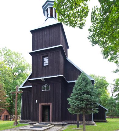 Zdjęcie nr 10: Kościół pw. św. Wawrzyńca w Grojcu jest drewnianą budowlą orientowaną, jednonawową z trójbocznie zamkniętym węższym prezbiterium od wschodu i wieżą od zachodu. Prostokątna nawa została wzniesiona na zrąb. Nawę i prezbiterium przykrywa dach siodłowy pokryty blachą cynkowaną. Do prezbiterium od północy przylega murowana zakrystia na rzucie prostokąta nakryta blaszanym dachem pulpitowym, a od południa prostokątny, drewniany aneks pełniący funkcję kaplicy bocznej, o podobnym dachu. Od północy do nawy dostawiono murowaną kaplicę na rzucie prostokąta przylegającą do zakrystii, a od południa niewielką czworoboczną kruchtę. Obie przestrzenie przykryto blaszanym dachem pulpitowym. W kruchcie południowej znajduje się drewniany portal z nadprożem w wykroju w ośli grzbiet. Nad wschodnią częścią nawy usytuowano sygnaturkę w kształcie wielobocznej latarni z krzyżem. Od zachodu do nawy dostawiono czworoboczną, drewnianą wieżę wzniesioną w konstrukcji słupowej, która w połowie nad nawą jest nadwieszona. Jej ściany są pionowe podzielone daszkami na trzy kondygnacje. Nakrywa ją blaszany, namiotowy hełm z latarnią zwieńczoną krzyżem. W przyziemiu wieży urządzono kruchtę. Wnętrze kościoła nakryto stropem z fasetą oddzieloną od ścian gzymsem. W zachodniej części nawy urządzono chór muzyczny zawieszony na dwóch kroksztynach i wsparty na kolumnach. W prezbiterium na ścianie wschodniej znajduje się ołtarz główny, a w nawie przy tęczy dwa ołtarze boczne oraz ambona.   