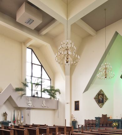 Zdjęcie nr 3: Orientowany kościół w Grojcu został wzniesiony jako świątynia salowa na rzucie wydłużonego prostokąta z nieznacznie wysuniętym poza zarys nawy transeptem. Nawę od wschodu kończy trójbocznie zamknięte prezbiterium, wpisane w obrys usytuowanej od wschodu prostokątnej zakrystii. Natomiast od zachodu zamyka ją nieznacznie wysunięta do przodu czworoboczna wieża, w przyziemiu której urządzono kruchtę. Wieżę wieńczy ostrosłupowy hełm z krzyżem wsparty na trójbocznych przyczółkach zamykających u góry płaszczyzny ścian bocznych. Poniżej hełmu widocznie są trójkątnie zamknięte, prostokątne okna, a pod nimi na ścianie zachodniej zainstalowany zegar. Po bokach wieży ściany nawy zostały przeprute monumentalnymi, trapezoidalnymi oknami doświetlającymi chór muzyczny i wnętrze świątyni. Podobne okna wprowadzono w ścianie południowej i północnej transeptu. Wnętrze kościoła nakryto żelbetonowym, płaskim stropem wspartym na łamanych filarach, stanowiących stylizowaną wersję sklepienia lustrzanego. W części zachodniej nawy oraz w ramionach transeptu wprowadzono połączone ze sobą empory. Na emporze zachodniej urządzono chór muzyczny ze współczesnym prospektem organowym. Prezbiterium zostało podniesione o kilka stopni w stosunku do poziomu posadzki nawy.  Ustawiono w nim marmurowy ołtarz posoborowy oraz ambonkę, dekorując środkową ścianę prezbiterium monumentalną, rzeźbioną postacią Chrystusa Zmartwychwstałego. Na ścianie północnej zawieszono w dekoracyjnej, romboidalnej ramie wizerunek Matki Boskiej Ostrobramskiej. 