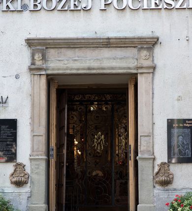 Zdjęcie nr 4: Kościół orientowany, jest budowlą murowaną z cegły i kamienia, na rzucie podłużnym. Korpus trójnawowy i dwuprzęsłowy. Prezbiterium trójprzęsłowe, zamknięte trójbocznie prezbiterium z przylegającymi od północy zakrystią, od południa kruchtą. Na osi kościoła, jednokondygnacyjna, szeroka, przysadzista wieża z kruchtą w przyziemiu i przyległością od zachodu.  Od południa i zachodu, w obrębie pierwszego przęsła naw bocznych jest para kaplic na rzutach zbliżonych do kwadratu. Nawa i prezbiterium przekryte są sklepieniami kolebkowymi z lunetami wspartymi na pilastrach i filarach. Kaplice wieńczą kopuły. Artykulację ścian na zewnątrz prezbiterium stanowi zespół przypór, naroża kaplic ujmują pilastry wpierające obiegający bryłę niepełne belkowanie.
Do wnętrza prowadzi 6 otworów drzwiowych, z czego 2 w kruchcie w wieży ujęte kamiennymi portalami zamkniętymi łukiem koszowym i do kaplicy ujętym kamiennym portalem w formie pary lizen na wysokich cokołach wspierających belkowanie z parą rozet w partii fryzu. Okna korpusu nawowego w kształcie stojących prostokątów, prezbiterium ostrołukowe, natomiast kaplic są prostokątne ujęte kamiennym obramieniem z uszakami w górnych narożach i zwieńczone trójkątnymi przyczółkami. Wieża artykułowana w 2/3 wysokości gzymsem. W dolnej strefie w 3 z 4 ścian po jednym, zamkniętym półkoliście oknie. W górnej partii pośrodku  z czterech po 1 okrągłej tarczy zegara. Wieże wieńczy hełm ujęty 4 latarniami i zwieńczony piątą. Dachy korpusu i prezbiterium dwuspadowe, nad kaplicami kopuły z latarniami, nad zakrystią i kruchtą boczną pulpitowe. Tynki ścian w odcieniach bieli i szarości. 
