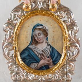 Zdjęcie nr 1: Feretron dwustronny z przedstawieniem Matki Bożej i św. Sebastiana. Na profilowanym postumencie zaopatrzonym w otwory na drążki do noszenia, dołem puklowanym, została umieszczona dwustronnie rzeźbiona, owalna rama utworzona z liści schnącego akantu, z dwoma aniołkami podtrzymującymi koronę w zwieńczeniu. Aniołki ukazano frontalnie, z jedną ręką złożoną na brzuchu, drugą wyprostowaną, podtrzymującą koronę w typie zamkniętym, ze złożonymi skrzydłami, z przepaską na biodrach utworzoną z liści akantu. Mają jasną karnację, szerokie twarze, zarumienione policzki, drobne, czerwone usta oraz krótkie, szerokie nosy. Włosy ciemnobrązowe, średniej długości, z przedziałkiem na środku. Na awersie znajduje się obraz z wizerunkiem popiersia Matki Bożej w owalnej ramie utworzonej z liści przewiązanych w czterech miejscach karbowaną wstęgą. Maria ukazana frontalnie, z głową delikatnie przechyloną w dół i zwróconą w prawo, z rękami złożonymi na piersi. Ubrana jest w białą suknię z długimi rękawami i niebieski płaszcz zarzucony na ramiona. Na głowie ma białą chustę i niebieski welon. Włosy długie, z przedziałkiem na środku, falowane. Dłonie subtelne, z długimi palcami, karnacja jasna, drobne usta, przymknięte powieki, długi, wąski nos. Wokół głowy Marii namalowano 11 gwiazd. Tło obrazu jasnożółte. Na rewersie obraz z przedstawieniem św. Sebastiana w owalnej, profilowanej, wypukłej ramie. W centrum kompozycji postać męczennika przywiązanego do drzewa. Jest zwrócony w trzech czwartych w lewo, delikatnie pochylony, z nogami ugiętymi w kolanach, rękami związanymi z tyłu. Ciało przebite czterema strzałami tkwiącymi w prawym ramieniu, lewym boku i obydwu nogach. Twarz podłużna z długim, wąskim nosem. U dołu po prawej aniołek, wysokością sięgający do połowy św. Sebastiana, ukazany z lewego profilu, wyciągający strzałę z boku świętego. Aniołek jest ubrany w niebieską szatę do kolan oraz czerwoną chustę zwiewnie unoszącą się ponad plecami. Ma twarz okrągłą, z wysuniętym podbródkiem, duże, szerokie usta, krótki, wąski nos, włosy średniej długości. W tle, po lewej stronie roślinność, po prawej błękitne niebo. Polichromia podstawy w kolorze brązowym i zielonym, rama i detale złocone i srebrzone.