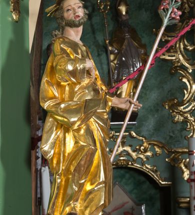 Zdjęcie nr 15: Nastawa ołtarzowa architektoniczna, jednoosiowa, jednokondygnacyjna ze zwieńczeniem. Mensa sarkofagowa, dekorowana na froncie dwiema płycinami w kształcie leżących prostokątów, ujętych po bokach i spiętych motywem ornamentalnym utworzonym z rocaille’a i liści.  
 Oś nastawy flankowana pilastrami przechodzącymi dołem w konsole i górą we fragmenty pełnego belkowania, o delikatnie wklęsło-wypukłej linii gzymsu. Zwieńczenie w formie wklęsło-wypukłej ujęte spływającymi na belkowanie dużymi wolutami, zamknięte stylizowanym gzymsem z ceowników i zwieńczone gołębicą Ducha Świętego na tle glorii, między główkami anielskimi, osadzone na obłoku. W polu środkowym pierwszej kondygnacji nisza z figurą Matki Boskiej Różańcowej wymiennie z obrazem ze sceną Zwiastowania ujęta profilowaną ramą w formie stojącego prostokąta zamkniętego łukiem półkolistym nadwieszonym z uskokiem, dekorowana fragmentami rocaille’ów. Na konsolach figury św. Joachima po lewej stronie i św. Józefa po prawej. W polu zwieńczenia obraz z przedstawieniem św. Rodziny ujęty ramą w formie trójlistnej, dekorowaną fragmentami rocaille'ów i flankowaną kwitnącymi gałązkami. Brzeg zwieńczenia i woluty zdobione taśmą i rocaille’ami, na wolutach para siedzących puttów, na zwieńczeniu uskrzydlone główki anielskie. 
Struktura polichromowana w kolorze zielonym, z marmoryzowanym cokołem i płycinami; ornamentyka i profile złocone i srebrzone.
