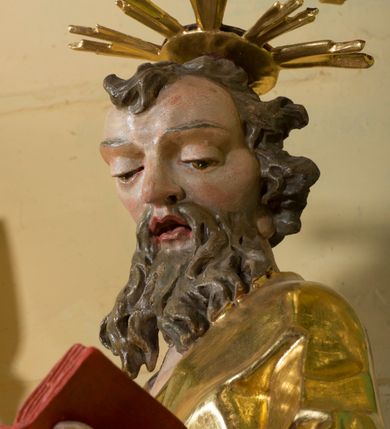 Zdjęcie nr 7: Rzeźba pełna, na cokole, ukazująca św. Joachima w całej postaci, w kontrapoście, frontalnie. Święty spogląda w dół, trzyma w lewej ręce otwartą książkę, w prawej dzierży łopatę pasterską. Ma owalną twarz o wąskich brwiach, dużych, migdałowatych oczach, dużym nosie i otwartych ustach, okoloną długą, rozdzielającą się na pół brodą i układającymi się w pukle włosami; nad głową nimb. Jest ubrany w długą suknię w dużym dekoltem, która podkreśla kształt ciała, łamiąc się grubymi fałdami. Na nogach ma sandały. Polichromia w partiach ciała naturalistyczna, szaty złocone, atrybuty złocone i srebrzone; krawędzie kart księgi w kolorze czerwonym. 