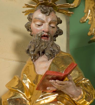 Zdjęcie nr 4: Rzeźba pełna, na cokole, ukazująca św. Joachima w całej postaci, w kontrapoście, frontalnie. Święty spogląda w dół, trzyma w lewej ręce otwartą książkę, w prawej dzierży łopatę pasterską. Ma owalną twarz o wąskich brwiach, dużych, migdałowatych oczach, dużym nosie i otwartych ustach, okoloną długą, rozdzielającą się na pół brodą i układającymi się w pukle włosami; nad głową nimb. Jest ubrany w długą suknię w dużym dekoltem, która podkreśla kształt ciała, łamiąc się grubymi fałdami. Na nogach ma sandały. Polichromia w partiach ciała naturalistyczna, szaty złocone, atrybuty złocone i srebrzone; krawędzie kart księgi w kolorze czerwonym. 