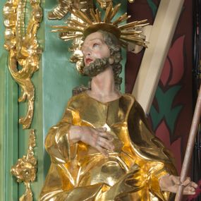 Zdjęcie nr 1: Rzeźba pełna, na cokole, ukazująca św. Józefa w całej postaci, w kontrapoście, frontalnie. Święty ma głowę zwróconą w prawo, prawą rękę przyciska do ciała, w lewej trzyma kwitnącą laskę. Ma prostokątną twarz o wąskich brwiach, dużych, migdałowatych oczach, dużym nosie i rozchylonych ustach, okoloną krótką brodą i układającymi się w pukle, długimi włosami. Jest ubrany w długą suknię w dużym dekoltem, która okleja ciało, łamiąc się grubymi fałdami. Na nogach ma sandały. Polichromia w partiach ciała naturalistyczna, szaty złocone, laska w kolorze brązowym, rozkwitające z niej kwiaty czerwone, na zielonych gałązkach.