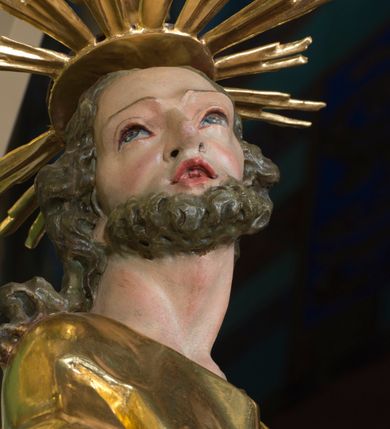 Zdjęcie nr 7: Rzeźba pełna, na cokole, ukazująca św. Józefa w całej postaci, w kontrapoście, frontalnie. Święty ma głowę zwróconą w prawo, prawą rękę przyciska do ciała, w lewej trzyma kwitnącą laskę. Ma prostokątną twarz o wąskich brwiach, dużych, migdałowatych oczach, dużym nosie i rozchylonych ustach, okoloną krótką brodą i układającymi się w pukle, długimi włosami. Jest ubrany w długą suknię w dużym dekoltem, która okleja ciało, łamiąc się grubymi fałdami. Na nogach ma sandały. Polichromia w partiach ciała naturalistyczna, szaty złocone, laska w kolorze brązowym, rozkwitające z niej kwiaty czerwone, na zielonych gałązkach.