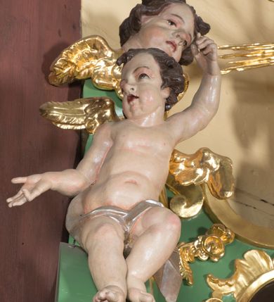 Zdjęcie nr 8: Nastawa ołtarzowa architektoniczna, jednoosiowa, jednokondygnacyjna ze zwieńczeniem. Mensa sarkofagowa, dekorowana na froncie dwiema płycinami w kształcie leżących prostokątów, ujętych po bokach i spiętych motywem ornamentalnym utworzonym z rocaille’a i liści. Oś nastawy flankowana pilastrami przechodzącymi dołem w konsole i górą we fragmenty pełnego belkowania, o delikatnie wklęsło-wypukłej linii gzymsu. Zwieńczenie w formie wklęsło-wypukłej ujęte spływającymi na belkowanie dużymi wolutami, zamknięte stylizowanym gzymsem z ceowników i zwieńczone wyobrażeniem oka Opatrzności, na tle glorii promienistej i obłoków. W polu środkowym pierwszej kondygnacji rzeźba ukazująca św. Mikołaja przesłaniana obrazem z przedstawieniem św. Antoniego Padewskiego adorującego Matkę Boską z Dzieciątkiem wykonanym w 1830 roku przez nowotarskiego malarza Tomasza Nankego, na zamówienie organisty Jakuba Pasigowskiego. Nisza ujęta profilowaną ramą w formie stojącego prostokąta zamkniętego łukiem półkolistym nadwieszonym z uskokiem, dekorowana fragmentami rocaille’ów. Na konsolach figury św. Jana Nepomucena po lewej stronie i św. Karola Boromeusza po prawej. W polu zwieńczenia obraz z przedstawieniem św. Agaty ujęty ramą w formie trójlistnej, dekorowaną fragmentami rocaille&#039;ów i flankowaną kwitnącymi gałązkami. Brzeg zwieńczenia i woluty zdobione taśmą i rocaille&#039;ami, na wolutach para siedzących puttów, na zwieńczeniu uskrzydlone główki anielskie. 
Struktura polichromowana w kolorze zielonym, z marmoryzowanym cokołem i płycinami; ornamentyka i profile złocone i srebrzone.
