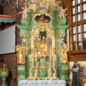 Zdjęcie nr 1: Nastawa ołtarzowa architektoniczna, jednoosiowa, jednokondygnacyjna ze zwieńczeniem. Mensa sarkofagowa, dekorowana na froncie dwiema płycinami w kształcie leżących prostokątów, ujętych po bokach i spiętych motywem ornamentalnym utworzonym z rocaille’a i liści. Oś nastawy flankowana pilastrami przechodzącymi dołem w konsole i górą we fragmenty pełnego belkowania, o delikatnie wklęsło-wypukłej linii gzymsu. Zwieńczenie w formie wklęsło-wypukłej ujęte spływającymi na belkowanie dużymi wolutami, zamknięte stylizowanym gzymsem z ceowników i zwieńczone wyobrażeniem oka Opatrzności, na tle glorii promienistej i obłoków. W polu środkowym pierwszej kondygnacji rzeźba ukazująca św. Mikołaja przesłaniana obrazem z przedstawieniem św. Antoniego Padewskiego adorującego Matkę Boską z Dzieciątkiem wykonanym w 1830 roku przez nowotarskiego malarza Tomasza Nankego, na zamówienie organisty Jakuba Pasigowskiego. Nisza ujęta profilowaną ramą w formie stojącego prostokąta zamkniętego łukiem półkolistym nadwieszonym z uskokiem, dekorowana fragmentami rocaille’ów. Na konsolach figury św. Jana Nepomucena po lewej stronie i św. Karola Boromeusza po prawej. W polu zwieńczenia obraz z przedstawieniem św. Agaty ujęty ramą w formie trójlistnej, dekorowaną fragmentami rocaille'ów i flankowaną kwitnącymi gałązkami. Brzeg zwieńczenia i woluty zdobione taśmą i rocaille'ami, na wolutach para siedzących puttów, na zwieńczeniu uskrzydlone główki anielskie. 
Struktura polichromowana w kolorze zielonym, z marmoryzowanym cokołem i płycinami; ornamentyka i profile złocone i srebrzone.
