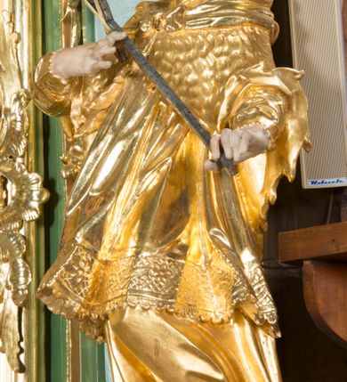 Zdjęcie nr 4: Nastawa ołtarzowa architektoniczna, jednoosiowa, jednokondygnacyjna ze zwieńczeniem. Mensa sarkofagowa, dekorowana na froncie dwiema płycinami w kształcie leżących prostokątów, ujętych po bokach i spiętych motywem ornamentalnym utworzonym z rocaille’a i liści. Oś nastawy flankowana pilastrami przechodzącymi dołem w konsole i górą we fragmenty pełnego belkowania, o delikatnie wklęsło-wypukłej linii gzymsu. Zwieńczenie w formie wklęsło-wypukłej ujęte spływającymi na belkowanie dużymi wolutami, zamknięte stylizowanym gzymsem z ceowników i zwieńczone wyobrażeniem oka Opatrzności, na tle glorii promienistej i obłoków. W polu środkowym pierwszej kondygnacji rzeźba ukazująca św. Mikołaja przesłaniana obrazem z przedstawieniem św. Antoniego Padewskiego adorującego Matkę Boską z Dzieciątkiem wykonanym w 1830 roku przez nowotarskiego malarza Tomasza Nankego, na zamówienie organisty Jakuba Pasigowskiego. Nisza ujęta profilowaną ramą w formie stojącego prostokąta zamkniętego łukiem półkolistym nadwieszonym z uskokiem, dekorowana fragmentami rocaille’ów. Na konsolach figury św. Jana Nepomucena po lewej stronie i św. Karola Boromeusza po prawej. W polu zwieńczenia obraz z przedstawieniem św. Agaty ujęty ramą w formie trójlistnej, dekorowaną fragmentami rocaille'ów i flankowaną kwitnącymi gałązkami. Brzeg zwieńczenia i woluty zdobione taśmą i rocaille'ami, na wolutach para siedzących puttów, na zwieńczeniu uskrzydlone główki anielskie. 
Struktura polichromowana w kolorze zielonym, z marmoryzowanym cokołem i płycinami; ornamentyka i profile złocone i srebrzone.
