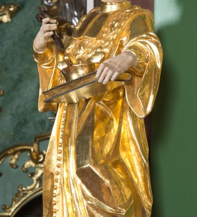 Zdjęcie nr 18: Nastawa ołtarzowa architektoniczna, jednoosiowa, jednokondygnacyjna ze zwieńczeniem. Mensa sarkofagowa, dekorowana na froncie dwiema płycinami w kształcie leżących prostokątów, ujętych po bokach i spiętych motywem ornamentalnym utworzonym z rocaille’a i liści. Oś nastawy flankowana pilastrami przechodzącymi dołem w konsole i górą we fragmenty pełnego belkowania, o delikatnie wklęsło-wypukłej linii gzymsu. Zwieńczenie w formie wklęsło-wypukłej ujęte spływającymi na belkowanie dużymi wolutami, zamknięte stylizowanym gzymsem z ceowników i zwieńczone wyobrażeniem oka Opatrzności, na tle glorii promienistej i obłoków. W polu środkowym pierwszej kondygnacji rzeźba ukazująca św. Mikołaja przesłaniana obrazem z przedstawieniem św. Antoniego Padewskiego adorującego Matkę Boską z Dzieciątkiem wykonanym w 1830 roku przez nowotarskiego malarza Tomasza Nankego, na zamówienie organisty Jakuba Pasigowskiego. Nisza ujęta profilowaną ramą w formie stojącego prostokąta zamkniętego łukiem półkolistym nadwieszonym z uskokiem, dekorowana fragmentami rocaille’ów. Na konsolach figury św. Jana Nepomucena po lewej stronie i św. Karola Boromeusza po prawej. W polu zwieńczenia obraz z przedstawieniem św. Agaty ujęty ramą w formie trójlistnej, dekorowaną fragmentami rocaille'ów i flankowaną kwitnącymi gałązkami. Brzeg zwieńczenia i woluty zdobione taśmą i rocaille'ami, na wolutach para siedzących puttów, na zwieńczeniu uskrzydlone główki anielskie. 
Struktura polichromowana w kolorze zielonym, z marmoryzowanym cokołem i płycinami; ornamentyka i profile złocone i srebrzone.
