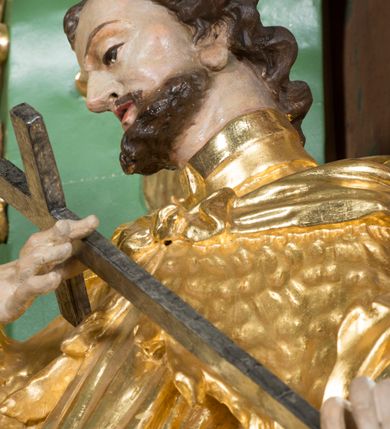 Zdjęcie nr 6: Rzeźba pełna, na cokole, ukazująca św. Karola Boromeusza, a dawniej św. Błażeja w całej postaci, w kontrapoście, frontalnie. Święty spogląda w dół, obiema rękami przytrzymuje krzyż. Ma prostokątną twarz o wąskich brwiach, dużych, migdałowatych oczach, dużym nosie i wyraźnie zarysowanych ustach, okoloną krótką brodą i układającymi się w pukle włosami. Jest ubrany w strój biskupa: długą albę, dekorowaną szerokim pasem koronki rokietę, futrzaną almucję oraz humerał. Na nogach ma buty o ściętych czubkach. Polichromia w partiach ciała naturalistyczna, szaty złocone, krzyż brązowy. 