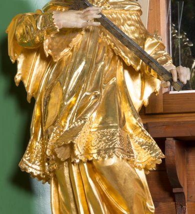 Zdjęcie nr 1: Rzeźba pełna, na cokole, ukazująca św. Karola Boromeusza, a dawniej św. Błażeja w całej postaci, w kontrapoście, frontalnie. Święty spogląda w dół, obiema rękami przytrzymuje krzyż. Ma prostokątną twarz o wąskich brwiach, dużych, migdałowatych oczach, dużym nosie i wyraźnie zarysowanych ustach, okoloną krótką brodą i układającymi się w pukle włosami. Jest ubrany w strój biskupa: długą albę, dekorowaną szerokim pasem koronki rokietę, futrzaną almucję oraz humerał. Na nogach ma buty o ściętych czubkach. Polichromia w partiach ciała naturalistyczna, szaty złocone, krzyż brązowy. 