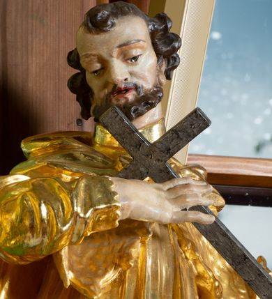 Zdjęcie nr 5: Rzeźba pełna, na cokole, ukazująca św. Karola Boromeusza, a dawniej św. Błażeja w całej postaci, w kontrapoście, frontalnie. Święty spogląda w dół, obiema rękami przytrzymuje krzyż. Ma prostokątną twarz o wąskich brwiach, dużych, migdałowatych oczach, dużym nosie i wyraźnie zarysowanych ustach, okoloną krótką brodą i układającymi się w pukle włosami. Jest ubrany w strój biskupa: długą albę, dekorowaną szerokim pasem koronki rokietę, futrzaną almucję oraz humerał. Na nogach ma buty o ściętych czubkach. Polichromia w partiach ciała naturalistyczna, szaty złocone, krzyż brązowy. 