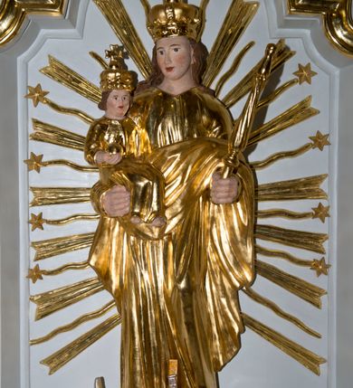 Zdjęcie nr 5: Nastawa ołtarzowa architektoniczna, jednoosiowa, jednokondygnacyjna ze zwieńczeniem. Ołtarz drewniany, prostopadłościenny, z drewnianą mensą. Antepedium w formie leżącego prostokąta obwiedzione profilem, z monogramem maryjnym po środku. Retabulum na niskim cokole, flankowane parą pilastrów przechodzących dołem w cokoły dla figur św. Wincentego Ferreriusza po lewej stronie i św. Jacka po prawej i konsole podtrzymujące fragmenty belkowania górą. Po dwóch stronach ażurowe uszaki utworzone z wici akantowej. Na konsolach umieszczono siedzące na chmurach aniołki wskazujące na Trójcę Świętą w zwieńczeniu. W dolnej części sceny stoją naprzeciwko siebie Chrystus oraz Bóg Ojciec stąpający po granatowych chmurach, ponad nimi unosi się gołębica Ducha Świętego na tle glorii promienistej, otoczona obłokami. Zwieńczenie zamknięte spływami wolutowymi dekorowanymi liśćmi. Nisza ujęta profilowaną ramą w formie stojącego prostokąta zamkniętego łukiem wklęsło-wypukłym z uskokami spiętą u góry ornamentem rocaille’owym. W niszy rzeźba Matki Boskiej Niepokalanie Poczętej. Struktura polichromowana na kolor biały, detale i ornamentyka złocone i srebrzone.  