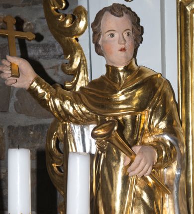 Zdjęcie nr 1: Rzeźba pełna, przedstawiająca św. Wincentego Ferreriusza, w całej postaci, ukazanego frontalnie. Święty skręca głowę w lewo, spogląda przed siebie, w prawej, uniesionej ręce trzyma krucyfiks, w lewej trąbkę. Ma owalną twarz z małymi oczami i ustami oraz wąskim nosem, na policzkach zaznaczone rumieńce; ma krótkie, kręcone włosy. Jest ubrany w habit z przełożoną stułą, na nogach ma trzewiki. Polichromia w partiach ciała naturalistyczna, szaty i atrybuty złocone i srebrzone.