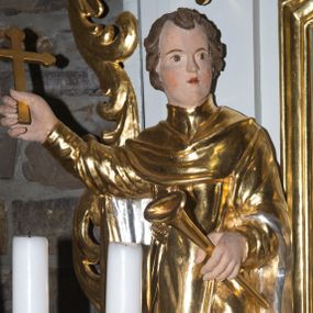 Zdjęcie nr 1: Rzeźba pełna, przedstawiająca św. Wincentego Ferreriusza, w całej postaci, ukazanego frontalnie. Święty skręca głowę w lewo, spogląda przed siebie, w prawej, uniesionej ręce trzyma krucyfiks, w lewej trąbkę. Ma owalną twarz z małymi oczami i ustami oraz wąskim nosem, na policzkach zaznaczone rumieńce; ma krótkie, kręcone włosy. Jest ubrany w habit z przełożoną stułą, na nogach ma trzewiki. Polichromia w partiach ciała naturalistyczna, szaty i atrybuty złocone i srebrzone.