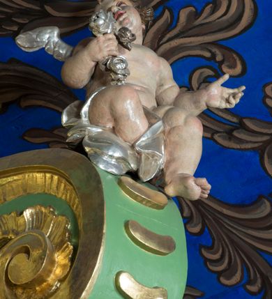 Zdjęcie nr 34: Nastawa ołtarzowa architektoniczna, jednoosiowa, jednokondygnacyjna ze zwieńczeniem oraz bramkami. Mensa sarkofagowa, dekorowana na froncie rokokowym kartuszem zawierającym datę odnowienia kościoła – 1869. Na niej tabernakulum w formie drewnianej skrzynki, o wklęsło-wypukłej ściance frontowej, flankowanej przez ukośnie dostawioną parę pilastrów na cokołach o trzonach w formie spływów wolutowych, dźwigających imposty oraz gzyms wyłamujący się w centrum w formę wspornika stanowiącego tron wystawienia. Całość ujęta ornamentalnymi spływami ustawionymi na cokole z prześwitami wypełnionymi kratką z krzyżykami. Drzwiczki w formie stojącego prostokąta zamkniętego łukiem półkolistym nadwieszonym, dekorowanym rocaille'em; w polu na fakturowanym tle płaskorzeźbione przedstawienie kielicha z hostią w glorii. 
Nastawa ołtarzowa ustawiona na dwustrefowym cokole, zryzalitowanym przy brzegach; ujęta wiązką pilastrów i stojącą przed nimi parą kolumn o kapitelach kompozytowych, dźwigających fragmenty pełnego belkowania, o delikatnie wklęsło-wypukłej linii gzymsu. Zwieńczenie w formie wklęsło-wypukłej, ujęte spływającymi na belkowanie dużymi wolutami, zamknięte stylizowanym gzymsem w formie łuku odcinkowego nadwieszonego z uskokiem. W polu środkowym pierwszej kondygnacji nisza z figurą Matki Boskiej Różańcowej wymiennie z figurą św. Sebastiana i obrazem z przedstawieniem męczeństwa św. Sebastiana, ujęta profilowaną ramą w formie stojącego prostokąta zamkniętego łukiem półkolistym nadwieszonym z uskokiem, dekorowana fragmentami rocaille'ów oraz zwieńczona ażurową konstrukcją utworzoną z rocaille'ów. Przed pilastrami rocaille’owe wsporniki z figurami św. Piotra i św. Pawła. W polu zwieńczenia obraz z przedstawieniem św. Floriana ujęty ramą w formie zbliżonej do koła z wpisanym kwadratem, dekorowaną fragmentami rocaille'ów i flankowaną zwisami utworzonymi z ulistnionych gałązek. Brzeg zwieńczenia i woluty zdobione rocaille’ową falbaną, na wolutach para siedzących puttów trzymających róże. Bramki ujęte od zewnątrz parą opilastrowanych filarów o trzonach dekorowanych rocaille'em, na których stoją figury św. Jana Ewangelisty po lewej i św. Jana Chrzciciela po prawej stronie. Przejścia w formie stojącego prostokąta zamkniętego łukiem odcinkowym nadwieszonym, z drzwiami o tym samym kształcie dekorowanymi płyciną z czterema uszakami, zakończoną trójkątnie z malowanymi na drewnie przedstawieniami Archanioła Michała po lewej i Archanioła Rafała po prawej stronie. Bramki zamknięte stylizowanym łukiem odcinkowym nadwieszonym dekorowanym rocaille'em zwieńczonym wspornikiem na rzeźby św. Stanisława i św. Wojciecha. Powyżej bramek proste ścianki zamknięte profilowanym gzymsem, wypełniające całą szerokość prezbiterium. 
Struktura polichromowana w kolorze zielonym, z marmoryzowanymi detalami i ściankami osi zewnętrznych; ornamentyka, profile i kolumny złocone i srebrzone.
