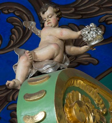 Zdjęcie nr 33: Nastawa ołtarzowa architektoniczna, jednoosiowa, jednokondygnacyjna ze zwieńczeniem oraz bramkami. Mensa sarkofagowa, dekorowana na froncie rokokowym kartuszem zawierającym datę odnowienia kościoła – 1869. Na niej tabernakulum w formie drewnianej skrzynki, o wklęsło-wypukłej ściance frontowej, flankowanej przez ukośnie dostawioną parę pilastrów na cokołach o trzonach w formie spływów wolutowych, dźwigających imposty oraz gzyms wyłamujący się w centrum w formę wspornika stanowiącego tron wystawienia. Całość ujęta ornamentalnymi spływami ustawionymi na cokole z prześwitami wypełnionymi kratką z krzyżykami. Drzwiczki w formie stojącego prostokąta zamkniętego łukiem półkolistym nadwieszonym, dekorowanym rocaille'em; w polu na fakturowanym tle płaskorzeźbione przedstawienie kielicha z hostią w glorii. 
Nastawa ołtarzowa ustawiona na dwustrefowym cokole, zryzalitowanym przy brzegach; ujęta wiązką pilastrów i stojącą przed nimi parą kolumn o kapitelach kompozytowych, dźwigających fragmenty pełnego belkowania, o delikatnie wklęsło-wypukłej linii gzymsu. Zwieńczenie w formie wklęsło-wypukłej, ujęte spływającymi na belkowanie dużymi wolutami, zamknięte stylizowanym gzymsem w formie łuku odcinkowego nadwieszonego z uskokiem. W polu środkowym pierwszej kondygnacji nisza z figurą Matki Boskiej Różańcowej wymiennie z figurą św. Sebastiana i obrazem z przedstawieniem męczeństwa św. Sebastiana, ujęta profilowaną ramą w formie stojącego prostokąta zamkniętego łukiem półkolistym nadwieszonym z uskokiem, dekorowana fragmentami rocaille'ów oraz zwieńczona ażurową konstrukcją utworzoną z rocaille'ów. Przed pilastrami rocaille’owe wsporniki z figurami św. Piotra i św. Pawła. W polu zwieńczenia obraz z przedstawieniem św. Floriana ujęty ramą w formie zbliżonej do koła z wpisanym kwadratem, dekorowaną fragmentami rocaille'ów i flankowaną zwisami utworzonymi z ulistnionych gałązek. Brzeg zwieńczenia i woluty zdobione rocaille’ową falbaną, na wolutach para siedzących puttów trzymających róże. Bramki ujęte od zewnątrz parą opilastrowanych filarów o trzonach dekorowanych rocaille'em, na których stoją figury św. Jana Ewangelisty po lewej i św. Jana Chrzciciela po prawej stronie. Przejścia w formie stojącego prostokąta zamkniętego łukiem odcinkowym nadwieszonym, z drzwiami o tym samym kształcie dekorowanymi płyciną z czterema uszakami, zakończoną trójkątnie z malowanymi na drewnie przedstawieniami Archanioła Michała po lewej i Archanioła Rafała po prawej stronie. Bramki zamknięte stylizowanym łukiem odcinkowym nadwieszonym dekorowanym rocaille'em zwieńczonym wspornikiem na rzeźby św. Stanisława i św. Wojciecha. Powyżej bramek proste ścianki zamknięte profilowanym gzymsem, wypełniające całą szerokość prezbiterium. 
Struktura polichromowana w kolorze zielonym, z marmoryzowanymi detalami i ściankami osi zewnętrznych; ornamentyka, profile i kolumny złocone i srebrzone.
