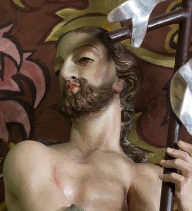 Zdjęcie nr 16: Nastawa ołtarzowa architektoniczna, jednoosiowa, jednokondygnacyjna ze zwieńczeniem oraz bramkami. Mensa sarkofagowa, dekorowana na froncie rokokowym kartuszem zawierającym datę odnowienia kościoła – 1869. Na niej tabernakulum w formie drewnianej skrzynki, o wklęsło-wypukłej ściance frontowej, flankowanej przez ukośnie dostawioną parę pilastrów na cokołach o trzonach w formie spływów wolutowych, dźwigających imposty oraz gzyms wyłamujący się w centrum w formę wspornika stanowiącego tron wystawienia. Całość ujęta ornamentalnymi spływami ustawionymi na cokole z prześwitami wypełnionymi kratką z krzyżykami. Drzwiczki w formie stojącego prostokąta zamkniętego łukiem półkolistym nadwieszonym, dekorowanym rocaille'em; w polu na fakturowanym tle płaskorzeźbione przedstawienie kielicha z hostią w glorii. 
Nastawa ołtarzowa ustawiona na dwustrefowym cokole, zryzalitowanym przy brzegach; ujęta wiązką pilastrów i stojącą przed nimi parą kolumn o kapitelach kompozytowych, dźwigających fragmenty pełnego belkowania, o delikatnie wklęsło-wypukłej linii gzymsu. Zwieńczenie w formie wklęsło-wypukłej, ujęte spływającymi na belkowanie dużymi wolutami, zamknięte stylizowanym gzymsem w formie łuku odcinkowego nadwieszonego z uskokiem. W polu środkowym pierwszej kondygnacji nisza z figurą Matki Boskiej Różańcowej wymiennie z figurą św. Sebastiana i obrazem z przedstawieniem męczeństwa św. Sebastiana, ujęta profilowaną ramą w formie stojącego prostokąta zamkniętego łukiem półkolistym nadwieszonym z uskokiem, dekorowana fragmentami rocaille'ów oraz zwieńczona ażurową konstrukcją utworzoną z rocaille'ów. Przed pilastrami rocaille’owe wsporniki z figurami św. Piotra i św. Pawła. W polu zwieńczenia obraz z przedstawieniem św. Floriana ujęty ramą w formie zbliżonej do koła z wpisanym kwadratem, dekorowaną fragmentami rocaille'ów i flankowaną zwisami utworzonymi z ulistnionych gałązek. Brzeg zwieńczenia i woluty zdobione rocaille’ową falbaną, na wolutach para siedzących puttów trzymających róże. Bramki ujęte od zewnątrz parą opilastrowanych filarów o trzonach dekorowanych rocaille'em, na których stoją figury św. Jana Ewangelisty po lewej i św. Jana Chrzciciela po prawej stronie. Przejścia w formie stojącego prostokąta zamkniętego łukiem odcinkowym nadwieszonym, z drzwiami o tym samym kształcie dekorowanymi płyciną z czterema uszakami, zakończoną trójkątnie z malowanymi na drewnie przedstawieniami Archanioła Michała po lewej i Archanioła Rafała po prawej stronie. Bramki zamknięte stylizowanym łukiem odcinkowym nadwieszonym dekorowanym rocaille'em zwieńczonym wspornikiem na rzeźby św. Stanisława i św. Wojciecha. Powyżej bramek proste ścianki zamknięte profilowanym gzymsem, wypełniające całą szerokość prezbiterium. 
Struktura polichromowana w kolorze zielonym, z marmoryzowanymi detalami i ściankami osi zewnętrznych; ornamentyka, profile i kolumny złocone i srebrzone.
