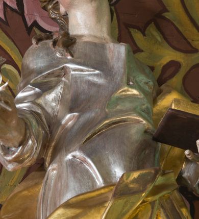 Zdjęcie nr 10: Nastawa ołtarzowa architektoniczna, jednoosiowa, jednokondygnacyjna ze zwieńczeniem oraz bramkami. Mensa sarkofagowa, dekorowana na froncie rokokowym kartuszem zawierającym datę odnowienia kościoła – 1869. Na niej tabernakulum w formie drewnianej skrzynki, o wklęsło-wypukłej ściance frontowej, flankowanej przez ukośnie dostawioną parę pilastrów na cokołach o trzonach w formie spływów wolutowych, dźwigających imposty oraz gzyms wyłamujący się w centrum w formę wspornika stanowiącego tron wystawienia. Całość ujęta ornamentalnymi spływami ustawionymi na cokole z prześwitami wypełnionymi kratką z krzyżykami. Drzwiczki w formie stojącego prostokąta zamkniętego łukiem półkolistym nadwieszonym, dekorowanym rocaille'em; w polu na fakturowanym tle płaskorzeźbione przedstawienie kielicha z hostią w glorii. 
Nastawa ołtarzowa ustawiona na dwustrefowym cokole, zryzalitowanym przy brzegach; ujęta wiązką pilastrów i stojącą przed nimi parą kolumn o kapitelach kompozytowych, dźwigających fragmenty pełnego belkowania, o delikatnie wklęsło-wypukłej linii gzymsu. Zwieńczenie w formie wklęsło-wypukłej, ujęte spływającymi na belkowanie dużymi wolutami, zamknięte stylizowanym gzymsem w formie łuku odcinkowego nadwieszonego z uskokiem. W polu środkowym pierwszej kondygnacji nisza z figurą Matki Boskiej Różańcowej wymiennie z figurą św. Sebastiana i obrazem z przedstawieniem męczeństwa św. Sebastiana, ujęta profilowaną ramą w formie stojącego prostokąta zamkniętego łukiem półkolistym nadwieszonym z uskokiem, dekorowana fragmentami rocaille'ów oraz zwieńczona ażurową konstrukcją utworzoną z rocaille'ów. Przed pilastrami rocaille’owe wsporniki z figurami św. Piotra i św. Pawła. W polu zwieńczenia obraz z przedstawieniem św. Floriana ujęty ramą w formie zbliżonej do koła z wpisanym kwadratem, dekorowaną fragmentami rocaille'ów i flankowaną zwisami utworzonymi z ulistnionych gałązek. Brzeg zwieńczenia i woluty zdobione rocaille’ową falbaną, na wolutach para siedzących puttów trzymających róże. Bramki ujęte od zewnątrz parą opilastrowanych filarów o trzonach dekorowanych rocaille'em, na których stoją figury św. Jana Ewangelisty po lewej i św. Jana Chrzciciela po prawej stronie. Przejścia w formie stojącego prostokąta zamkniętego łukiem odcinkowym nadwieszonym, z drzwiami o tym samym kształcie dekorowanymi płyciną z czterema uszakami, zakończoną trójkątnie z malowanymi na drewnie przedstawieniami Archanioła Michała po lewej i Archanioła Rafała po prawej stronie. Bramki zamknięte stylizowanym łukiem odcinkowym nadwieszonym dekorowanym rocaille'em zwieńczonym wspornikiem na rzeźby św. Stanisława i św. Wojciecha. Powyżej bramek proste ścianki zamknięte profilowanym gzymsem, wypełniające całą szerokość prezbiterium. 
Struktura polichromowana w kolorze zielonym, z marmoryzowanymi detalami i ściankami osi zewnętrznych; ornamentyka, profile i kolumny złocone i srebrzone.
