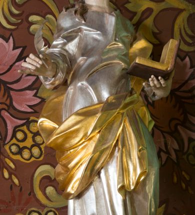 Zdjęcie nr 9: Nastawa ołtarzowa architektoniczna, jednoosiowa, jednokondygnacyjna ze zwieńczeniem oraz bramkami. Mensa sarkofagowa, dekorowana na froncie rokokowym kartuszem zawierającym datę odnowienia kościoła – 1869. Na niej tabernakulum w formie drewnianej skrzynki, o wklęsło-wypukłej ściance frontowej, flankowanej przez ukośnie dostawioną parę pilastrów na cokołach o trzonach w formie spływów wolutowych, dźwigających imposty oraz gzyms wyłamujący się w centrum w formę wspornika stanowiącego tron wystawienia. Całość ujęta ornamentalnymi spływami ustawionymi na cokole z prześwitami wypełnionymi kratką z krzyżykami. Drzwiczki w formie stojącego prostokąta zamkniętego łukiem półkolistym nadwieszonym, dekorowanym rocaille'em; w polu na fakturowanym tle płaskorzeźbione przedstawienie kielicha z hostią w glorii. 
Nastawa ołtarzowa ustawiona na dwustrefowym cokole, zryzalitowanym przy brzegach; ujęta wiązką pilastrów i stojącą przed nimi parą kolumn o kapitelach kompozytowych, dźwigających fragmenty pełnego belkowania, o delikatnie wklęsło-wypukłej linii gzymsu. Zwieńczenie w formie wklęsło-wypukłej, ujęte spływającymi na belkowanie dużymi wolutami, zamknięte stylizowanym gzymsem w formie łuku odcinkowego nadwieszonego z uskokiem. W polu środkowym pierwszej kondygnacji nisza z figurą Matki Boskiej Różańcowej wymiennie z figurą św. Sebastiana i obrazem z przedstawieniem męczeństwa św. Sebastiana, ujęta profilowaną ramą w formie stojącego prostokąta zamkniętego łukiem półkolistym nadwieszonym z uskokiem, dekorowana fragmentami rocaille'ów oraz zwieńczona ażurową konstrukcją utworzoną z rocaille'ów. Przed pilastrami rocaille’owe wsporniki z figurami św. Piotra i św. Pawła. W polu zwieńczenia obraz z przedstawieniem św. Floriana ujęty ramą w formie zbliżonej do koła z wpisanym kwadratem, dekorowaną fragmentami rocaille'ów i flankowaną zwisami utworzonymi z ulistnionych gałązek. Brzeg zwieńczenia i woluty zdobione rocaille’ową falbaną, na wolutach para siedzących puttów trzymających róże. Bramki ujęte od zewnątrz parą opilastrowanych filarów o trzonach dekorowanych rocaille'em, na których stoją figury św. Jana Ewangelisty po lewej i św. Jana Chrzciciela po prawej stronie. Przejścia w formie stojącego prostokąta zamkniętego łukiem odcinkowym nadwieszonym, z drzwiami o tym samym kształcie dekorowanymi płyciną z czterema uszakami, zakończoną trójkątnie z malowanymi na drewnie przedstawieniami Archanioła Michała po lewej i Archanioła Rafała po prawej stronie. Bramki zamknięte stylizowanym łukiem odcinkowym nadwieszonym dekorowanym rocaille'em zwieńczonym wspornikiem na rzeźby św. Stanisława i św. Wojciecha. Powyżej bramek proste ścianki zamknięte profilowanym gzymsem, wypełniające całą szerokość prezbiterium. 
Struktura polichromowana w kolorze zielonym, z marmoryzowanymi detalami i ściankami osi zewnętrznych; ornamentyka, profile i kolumny złocone i srebrzone.
