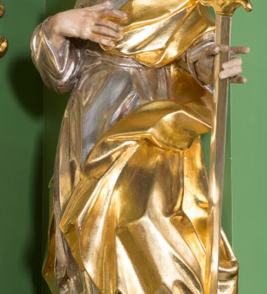 Zdjęcie nr 1: Rzeźba przedstawiająca św. Pawła w całej postaci. Figura ustawiona frontalnie, w kontrapoście, z głową pochyloną do przodu, prawą ręką spoczywającą na piersi, lewą wyciągniętą w bok, trzymającą miecz zwrócony ostrzem w dół. Twarz szczupła z wysokim czołem, o wyraźnie widocznych łukach brwiowych, dużym, zaoblonym nosie i zaznaczonych kościach policzkowych, okolona długą brodą silnie skręconą w pukle i głęboko rzeźbioną oraz krótkimi, silnie skręconymi włosami. Święty jest ubrany w długą suknię przewiązaną w talii oraz płaszcz podtrzymywany na piersi, przerzucony przez lewe ramię. Polichromia naturalistyczna w odsłoniętych partiach ciała, szaty i atrybuty złocone i srebrzone.