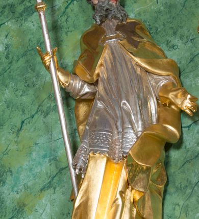 Zdjęcie nr 1: Rzeźba przedstawia św. Wojciecha w całej postaci. Figura ukazana frontalnie, w kontrapoście, z głową skierowaną w lewo, w prawej ręce trzyma pastorał, lewą wyciąga delikatnie w bok. Twarz ma szczupłą, oczy skierowane w dół, nos duży, zaoblony. Twarz jest okolona długą brodą opadającą w silnie skręconych puklach na pierś oraz krótkimi, skręconymi włosami. Święty jest ubrany w długą tunikę, rokietę z płaskorzeźbioną koronką przy brzegu oraz kapę zapiętą na piersi, opadającą na ramiona i zawiniętą na lewym boku; na głowie ma infułę, a na dłoniach rękawiczki. Polichromia naturalistyczna w odsłoniętych partiach ciała, szaty i atrybuty złocone i srebrzone.