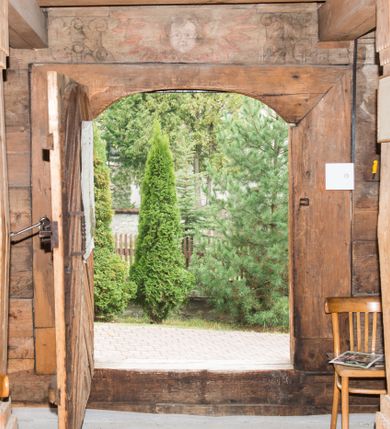 Zdjęcie nr 33: Kościół św. Elżbiety Węgierskiej w Trybszu usytuowany jest w centrum wsi na południe od drogi prowadzącej z Łapsz Wyżnych do Nowego Targu. Teren przykościelny jest otoczony od południa drewnianym ogrodzenie z murowanymi słupkami i kamienną podmurówką, z pozostałych stron mur z polnych kamieni, nakryty daszkiem cementowym. Główne wejście na teren przykościelny od północy, od zachodu bramka prowadząca do nowego kościoła, od południa furtka na cmentarz. Od zachodu główne wejście flankowane słupkami. Na placu przykościelnym stara lipa, w niej krucyfiks w kapliczkowej, szafkowej oprawie. W zachodniej części sztuczna grota, murowana z polnych kamieni z figurą Matki Boskiej z Lourdes. 

Kościół jest orientowany, drewniany o konstrukcji zrębowej, jednonawowy z wydłużonym prezbiterium zamkniętym trójbocznie, z kruchtą od południa i pierwotnie z zakrystią od północy i wieżą od zachodu. Wnętrze nakryte pułapem, w nawie z zaskrzynieniami, wiązanie nawy oparte nie na ścianach lecz na belkach podciągowych, których jeden koniec jest w ścianie tęczy, drugi zaś w czołowej ścianie nawy. Na zachodniej ścianie nawy chór muzyczny wsparty na dwóch filarach. Wnętrze oświetlają umieszczone w południowej ścianie trzy okna (dwa w prezbiterium i jedno w nawie). Ściany i stropy pokryte polichromią. Do kościoła prowadzi główne wejście od strony zachodniej oraz jedno przez kruchtę od południa. Dach o jednej kalenicy, gontowy, na środku drewniana sygnaturka, nakryta kopułką. Portal do zakrystii o wykroju w tzw. ośli grzbiet. 

