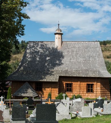 Zdjęcie nr 3: Kościół św. Elżbiety Węgierskiej w Trybszu usytuowany jest w centrum wsi na południe od drogi prowadzącej z Łapsz Wyżnych do Nowego Targu. Teren przykościelny jest otoczony od południa drewnianym ogrodzenie z murowanymi słupkami i kamienną podmurówką, z pozostałych stron mur z polnych kamieni, nakryty daszkiem cementowym. Główne wejście na teren przykościelny od północy, od zachodu bramka prowadząca do nowego kościoła, od południa furtka na cmentarz. Od zachodu główne wejście flankowane słupkami. Na placu przykościelnym stara lipa, w niej krucyfiks w kapliczkowej, szafkowej oprawie. W zachodniej części sztuczna grota, murowana z polnych kamieni z figurą Matki Boskiej z Lourdes. 

Kościół jest orientowany, drewniany o konstrukcji zrębowej, jednonawowy z wydłużonym prezbiterium zamkniętym trójbocznie, z kruchtą od południa i pierwotnie z zakrystią od północy i wieżą od zachodu. Wnętrze nakryte pułapem, w nawie z zaskrzynieniami, wiązanie nawy oparte nie na ścianach lecz na belkach podciągowych, których jeden koniec jest w ścianie tęczy, drugi zaś w czołowej ścianie nawy. Na zachodniej ścianie nawy chór muzyczny wsparty na dwóch filarach. Wnętrze oświetlają umieszczone w południowej ścianie trzy okna (dwa w prezbiterium i jedno w nawie). Ściany i stropy pokryte polichromią. Do kościoła prowadzi główne wejście od strony zachodniej oraz jedno przez kruchtę od południa. Dach o jednej kalenicy, gontowy, na środku drewniana sygnaturka, nakryta kopułką. Portal do zakrystii o wykroju w tzw. ośli grzbiet. 

