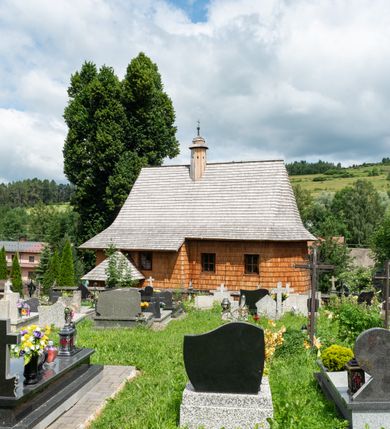 Zdjęcie nr 12: Kościół św. Elżbiety Węgierskiej w Trybszu usytuowany jest w centrum wsi na południe od drogi prowadzącej z Łapsz Wyżnych do Nowego Targu. Teren przykościelny jest otoczony od południa drewnianym ogrodzenie z murowanymi słupkami i kamienną podmurówką, z pozostałych stron mur z polnych kamieni, nakryty daszkiem cementowym. Główne wejście na teren przykościelny od północy, od zachodu bramka prowadząca do nowego kościoła, od południa furtka na cmentarz. Od zachodu główne wejście flankowane słupkami. Na placu przykościelnym stara lipa, w niej krucyfiks w kapliczkowej, szafkowej oprawie. W zachodniej części sztuczna grota, murowana z polnych kamieni z figurą Matki Boskiej z Lourdes. 

Kościół jest orientowany, drewniany o konstrukcji zrębowej, jednonawowy z wydłużonym prezbiterium zamkniętym trójbocznie, z kruchtą od południa i pierwotnie z zakrystią od północy i wieżą od zachodu. Wnętrze nakryte pułapem, w nawie z zaskrzynieniami, wiązanie nawy oparte nie na ścianach lecz na belkach podciągowych, których jeden koniec jest w ścianie tęczy, drugi zaś w czołowej ścianie nawy. Na zachodniej ścianie nawy chór muzyczny wsparty na dwóch filarach. Wnętrze oświetlają umieszczone w południowej ścianie trzy okna (dwa w prezbiterium i jedno w nawie). Ściany i stropy pokryte polichromią. Do kościoła prowadzi główne wejście od strony zachodniej oraz jedno przez kruchtę od południa. Dach o jednej kalenicy, gontowy, na środku drewniana sygnaturka, nakryta kopułką. Portal do zakrystii o wykroju w tzw. ośli grzbiet. 

