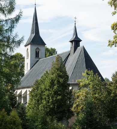 Zdjęcie nr 4: Kościół św. Antoniego Padewskiego w Trybszu jest usytuowany w centrum wsi, na południe od głównej drogi prowadzącej z Łapsz Wyżnych do Nowego Targu. Teren przykościelny jest otoczony wysokim murem, częściowo żeliwnym na kamiennej podmurówce, częściowo murowanym nakrytym cementowym daszkiem. Wejście od strony wschodniej oraz zachodniej przez szerokie bramy.

Kościół jest orientowany, murowany, otynkowany, jednonawowy z czworoboczną wieżą w fasadzie z prezbiterium zamkniętym trójbocznie. Dwuprzęsłowe prezbiterium oddziela od nawy szeroka ściana arkady tęczowej, zamknięte ostrołukowo. Nawa jest szersza i dłuższa, pięcioprzęsłowa. Wnętrze artykułowane jest dużymi i szerokimi oknami w kształcie stojących prostokątów, zamkniętych ostrołukowo, wypełnionych witrażami. Od południa do nawy przylega niewielka kruchta, a do prezbiterium od północy zakrystia. Na zachodniej ścianie nawy chór muzyczny wsparty na dwóch filarach, dostępny schodami od południowej strony nawy. Do kościoła prowadzi główne wejście od strony zachodniej oraz dwa mniejsze od strony południowej przez kruchtę i od strony północnej przez zakrystię.

W zewnętrznej elewacji kościoła widoczny jest niewysoki cokół, powyżej kościół otynkowany. Prezbiterium, o tej samej wysokości co nawa, lecz węższe z sygnaturką zwieńczoną iglicą. Nawa i prezbiterium oszkarpowane, nakryte dachem dwuspadowym. Do zachodniej fasady kościoła dostawiona jest wysoka założona na planie kwadratu wieża-dzwonnica. W dolnej kondygnacji na osi kościoła prostokątne wejście do kruchty, flankowane dwiema szkarpami. Fasada wieży w całości pokryta blachą, przechodzącą nad głównym wejściem do kościoła w daszek. Wieża zwieńczona iglicą.
