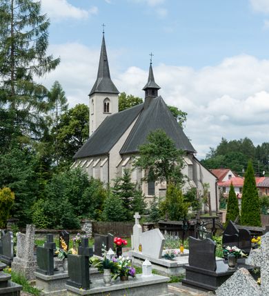 Zdjęcie nr 6: Kościół św. Antoniego Padewskiego w Trybszu jest usytuowany w centrum wsi, na południe od głównej drogi prowadzącej z Łapsz Wyżnych do Nowego Targu. Teren przykościelny jest otoczony wysokim murem, częściowo żeliwnym na kamiennej podmurówce, częściowo murowanym nakrytym cementowym daszkiem. Wejście od strony wschodniej oraz zachodniej przez szerokie bramy.

Kościół jest orientowany, murowany, otynkowany, jednonawowy z czworoboczną wieżą w fasadzie z prezbiterium zamkniętym trójbocznie. Dwuprzęsłowe prezbiterium oddziela od nawy szeroka ściana arkady tęczowej, zamknięte ostrołukowo. Nawa jest szersza i dłuższa, pięcioprzęsłowa. Wnętrze artykułowane jest dużymi i szerokimi oknami w kształcie stojących prostokątów, zamkniętych ostrołukowo, wypełnionych witrażami. Od południa do nawy przylega niewielka kruchta, a do prezbiterium od północy zakrystia. Na zachodniej ścianie nawy chór muzyczny wsparty na dwóch filarach, dostępny schodami od południowej strony nawy. Do kościoła prowadzi główne wejście od strony zachodniej oraz dwa mniejsze od strony południowej przez kruchtę i od strony północnej przez zakrystię.

W zewnętrznej elewacji kościoła widoczny jest niewysoki cokół, powyżej kościół otynkowany. Prezbiterium, o tej samej wysokości co nawa, lecz węższe z sygnaturką zwieńczoną iglicą. Nawa i prezbiterium oszkarpowane, nakryte dachem dwuspadowym. Do zachodniej fasady kościoła dostawiona jest wysoka założona na planie kwadratu wieża-dzwonnica. W dolnej kondygnacji na osi kościoła prostokątne wejście do kruchty, flankowane dwiema szkarpami. Fasada wieży w całości pokryta blachą, przechodzącą nad głównym wejściem do kościoła w daszek. Wieża zwieńczona iglicą.
