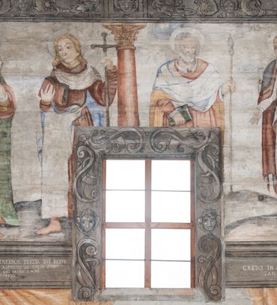 Zdjęcie nr 47: Polichromia ścienna obiegająca całe wnętrze świątyni wraz ze stropem, na ścianach kompozycje dwustrefowe. Strefy odgraniczone malowanym, profilowanym szarym cokołem z konsolami oraz umieszczonymi między nimi napisami. Na osi konsol, w drugiej strefie kolumny oddzielające poszczególne sceny. Kolumny ustawione na złoconych bazach, trzony malowane na czerwono, kapitele stylizowane na korynckie. Podpory podtrzymują malowany szary fryz zdobiony maskami, uskrzydlonymi główkami anielskimi oraz liśćmi wawrzynu.

Ściana północna nawy
W dolnej strefie znajduje się przedstawienie, tzw. Sąd Krwi, odbywający się w pałacu Kajfasza. Pośrodku sceny stoi Kajfasz na podwyższeniu ubrany w strój kapłana żydowskiego, na tle czarnej kotary. U góry napis cześciowo nieczytelny: „SAIPHAS / PONTIFEX / (?) OMNES QVID VELATIS PRAESTAT MNV(?) MORI QVAM / (?) VNIVE SV(?) POPULV (?) DE (?)RE”. Po prawej stronie kompozycji siedzi na kamiennym podeście Chrystus zwrócony trzy czwarte w prawo. Ubrany jest w czerwoną suknię, na głowie ma założoną koronę cierniową, a wokół niej kolisty nimb. Po obu stronach Kajfasza znajdują się liczni członkowie Sanhedrynu, którzy trzymają w dłoniach zwoje z ich imionami oraz orzeczeniami winy, część z nich jest nieczytelna: „INCOGNITA CAV/SA MORTI OBU(?)/EN BVS”, „(?) / ROGAT / NOR(?)M (?) / HIC (?)OMC PE(?)A /VIT”, „PAD / (?)EDV(?) / (?)T / (?)N”, „(?)SMO(?) / (?)HIN (?)”, „RIPHA(?) / LEX IN (?)”, „QRAM / QVARE SINE/MVS VIRVM / (?) QVIA / IVSTVS EST / MORTE DAM(?)”, „EM / IVSTVS / MAXIME QVV / POPVLVM SV(?) / CONCIONIRVS / (?)IONEM / (?)ONC(?)”, „NECODE / (?)CEM ACC(?) / PVLV SEDVCD / MORTE DIGNUS(?) /EST”, „(?)TRIE / (?)NITIE”, „MES / SI(?)VSTVS / EST CONVER / (?)AMVR ADI/(?)VM SINE / (?)VST (?)”, „SAMEOH / SI NEC IV/STVS EST NEC / INIVSTVS Q (?)/TAMEN MO(?)/MVR: C(?) / NON CI (?) /MORTE / EL EXILI / O IPSV / DAMNA/MVS”. Ponadto zachowane pojedyncze litery w dolnej części sceny oraz fragmenty długiego napisu po prawej u góry: „(?) CRV(?) (…) NOS / ET SVP(?)R FILIOS”. W górnej strefie od lewej strony pierwsza kwatera nieczytelna. W drugiej znajduje się scena ukazująca Chrystusa Zmartwychwstałego odwiedzającego Matkę Boską. Poniżej w partii cokołu napis: „T(?) ITA EVIT SVBIIT TAMEN A SPERA MORIS / N(?)LA SED STRATA MORTE RESVRGIT”. W drugiej kwaterze Pokłon Trzech Króli, opatrzony napisem: „CURVATO REGES VENER NTVR POPLITE REGEM / REGYM. NEC MIRUMOIVS DOCET OFFICIVM”. W ostatniej scena ukazująca Boże Narodzenie z podpisem: „VIRGO (?)NTIVSI(?)E P(?)VOD DINERAT ANTE / JAM(?) NIS PALPAS UPERE NVI S. ANAS”.

Ściana łuku arkady tęczowej
Po stronie północnej – dolna strefa nieczytelna, w górnej przedstawienie św. Jerzego na koniu walczącego ze smokiem. Po stronie południowej arkady tęczowej w górnej strefie św. Marcin ucinający połę swojego płaszcza dla żebraka. 

Prezbiterium
Na ścianie północnej lewa strona strefy dolnej niezachowana, dalej drzwi do zakrystii flankowane parą kolumn o czarnych trzonach i korynckich kapitelach. W nadprożu scena ukazująca Chrystusa Zmartwychwstałego Triumfującego, który jedzie na zaprzężonym w trzy baranki powozie. Na tyle pojazdu leżą narzędzia Męki Pańskiej. W prawym górnym narożu sceny napis: „IESVS TRIVMPHANS”. Kolejna scena przedstawia dwie święte niewiasty oraz ucztę. Scena w najnowszej literaturze interpretowana jest jako usługiwanie św. Elżbiety ubogim i chorym. W górnej strefie od lewej strony zostały ukazane następujące przedstawienia i podpisy: Nawiedzenie Najświętszej Marii Panny opisane słowami: „VISITAT ELEGTA IN GENITRICEM VIRCO TONANTIS / MA(?) (?)OMINIS PVRI VERA PARENS OVE DEI”. Kolejna scena przedstawia Zwiastowanie Najświętszej Marii Pannie: „TER QVE QVATER Q3 BEATA, ES VIRGO TE FORE MATRE / ANGELVS A CAELO DETONAT ORE DEI”. Następna kwatera ukazuje Matkę Boską Niepokalanie Poczętą. Po jej bokach znajdują się dwa anioły unoszące białe banderole z napisami: „FIA(?)MINA PLVENS CAELLS EST SVME GRATIA REGIS / A TE QVA RERIT VIRGO SIGMA (?)” oraz „CVMBA NATAT SVPIRI MARE. SED NON FLVC T. FRGO / MVNDANI FLCTIS NON TIM(?)”. W narożach symbole Litanii Loretańskiej w medalionach opisane kolejno słowami: „PER HAEC PRAESERVOR”, „FLVCTVS NON VEREOR”, „EXSPINIS SINE SPINIS ORIOR” oraz „(?)AVDOR NOCTI / LVCI APERIOR”. Poniżej sceny słabo czytelny napis: „INSIDIABARIS MALEDICTE VENENIGER ANGVIS / HV(?) (?)ENERI FAVCIBVS I GNIVS ME / (?) MVLIEREM DIRE (?)RANE / (?)PSE KIECAEM”. Poniżej przedstawienia, w partii cokołu napis: „ECCE ENIM EX HOC BEATAM ME / DICENT OMNES GENERATIONES”. W kolejnej kwaterze św. Elżbieta Węgierska i inskrypcja na cokole: „ARE ODIVA ELIZABETH: NAM TVA CLARENT / RIO MORES NOMINA FACTA POLO”.  Dalej św. Stanisław Biskup: „DIVE STANISLAE HIC MVLT LOCVS AMBIT ET OBTAT / SIS PATER ELIZABETH PATRONA SI(?)”. W części środkowej apsydy dolna cześć niezachowana, w górnej przedstawienie Mojżesza oraz Aarona. Na ścianie południowej prezbiterium w strefie dolnej ukazani kolejno czterej ojcowie Kościoła, opisani: św. Augustyn „S(ANCTVS) AVGVSTINVS”, św. Hieronim „S(ANCTVS) HIER(ONIM)”, św. Grzegorz Wielki „S(ANCTVS) GREGORIVS” oraz św. Ambroży. W strefie górnej, od lewej: św. Jan Kanty. W partii cokołowej napis: „(?) HIC EST quo PATRIARHA ACADEMIA GAVDET / (?)qucm Felic aedicai Astricolam / (?)arior hospes ades Canti no us oris / hic habites oni Alumnus Armans”. W kolejnej kwaterze ukazani są św. Piotr oraz św. Andrzej: „CREDO IN DEVM PATREM OMNIPOTENTE CREATORE CA(?)ETERE ET IN IESVM CHRI/STVM FILIVM (?)VS VNICVM DOMINVM / NOSTRVM”. Następnie św. Bartłomiej i św. Filip: „DESCENDIT AD INFEROS, TERTIA DIE RESVB / REXIT AMORTVIS ASCENDIT, AD CAELOS SEDENT, A DEXTERAM DEI PATRIS OMNI: / POTENTIS”. W ostatniej kwaterze prezbiterium ukazani są św. Tomasz oraz drugi, nierozpoznany apostoł: „CREDO IN SPIRITVM / SANCTVM”.

Ściana północna nawy
Polichromia na ścianie północnej częściowo niezachowana. W dolnej strefie scena ukazująca Modlitwę w Ogrójcu oraz narzędzia Męki Pańskiej: „(?)S SALVATOR / M(?)”. W górnej strefie kolejni dwaj apostołowie: św. Szymon i św. Juda Tadeusz: „SANCTA(?) / MVNION (?)”. Kolejna kwatera nieczytelna.

Balustrada chóru muzycznego
Balustradę chóru muzycznego zdobią alegorie siedmiu grzechów głównych pod postacią kobiet i towarzyszących im atrybutów, pierwsza z lewej Pycha, następna Chciwość, kolejne nieczytelne. Pod chórem muzycznym uskrzydlona główka aniołka nad portalem wejściowym, a po prawej stronie napis: „SPECVLVM / (?) MAI(?) OMNIB(?) VI(?)SIM(?) (?) CADENTI V RESCAT / (?)”.

Strop
Kompozycja stropu podzielona na trzy strefy, dwie duże boczne oraz wąską, środkową. W pierwszej strefie bocznej umieszczona jest rozbudowana kompozycja przedstawiająca Wniebowzięcie Najświętszej Marii Panny. W dolnej strefie pusty grób oraz apostołowie. Matkę Boską otaczają grupy muzykujących aniołów, u góry stoi Chrystus. W strefie środkowej ukazana została Koronacja Matki Boskiej, a w drugiej strefie bocznej Sąd Ostateczny. Partia malowideł na stropie również dookoła opatrzona jest napisami, lecz nieczytelnymi. 
