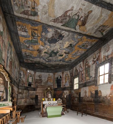 Zdjęcie nr 3: Polichromia ścienna obiegająca całe wnętrze świątyni wraz ze stropem, na ścianach kompozycje dwustrefowe. Strefy odgraniczone malowanym, profilowanym szarym cokołem z konsolami oraz umieszczonymi między nimi napisami. Na osi konsol, w drugiej strefie kolumny oddzielające poszczególne sceny. Kolumny ustawione na złoconych bazach, trzony malowane na czerwono, kapitele stylizowane na korynckie. Podpory podtrzymują malowany szary fryz zdobiony maskami, uskrzydlonymi główkami anielskimi oraz liśćmi wawrzynu.

Ściana północna nawy
W dolnej strefie znajduje się przedstawienie, tzw. Sąd Krwi, odbywający się w pałacu Kajfasza. Pośrodku sceny stoi Kajfasz na podwyższeniu ubrany w strój kapłana żydowskiego, na tle czarnej kotary. U góry napis cześciowo nieczytelny: „SAIPHAS / PONTIFEX / (?) OMNES QVID VELATIS PRAESTAT MNV(?) MORI QVAM / (?) VNIVE SV(?) POPULV (?) DE (?)RE”. Po prawej stronie kompozycji siedzi na kamiennym podeście Chrystus zwrócony trzy czwarte w prawo. Ubrany jest w czerwoną suknię, na głowie ma założoną koronę cierniową, a wokół niej kolisty nimb. Po obu stronach Kajfasza znajdują się liczni członkowie Sanhedrynu, którzy trzymają w dłoniach zwoje z ich imionami oraz orzeczeniami winy, część z nich jest nieczytelna: „INCOGNITA CAV/SA MORTI OBU(?)/EN BVS”, „(?) / ROGAT / NOR(?)M (?) / HIC (?)OMC PE(?)A /VIT”, „PAD / (?)EDV(?) / (?)T / (?)N”, „(?)SMO(?) / (?)HIN (?)”, „RIPHA(?) / LEX IN (?)”, „QRAM / QVARE SINE/MVS VIRVM / (?) QVIA / IVSTVS EST / MORTE DAM(?)”, „EM / IVSTVS / MAXIME QVV / POPVLVM SV(?) / CONCIONIRVS / (?)IONEM / (?)ONC(?)”, „NECODE / (?)CEM ACC(?) / PVLV SEDVCD / MORTE DIGNUS(?) /EST”, „(?)TRIE / (?)NITIE”, „MES / SI(?)VSTVS / EST CONVER / (?)AMVR ADI/(?)VM SINE / (?)VST (?)”, „SAMEOH / SI NEC IV/STVS EST NEC / INIVSTVS Q (?)/TAMEN MO(?)/MVR: C(?) / NON CI (?) /MORTE / EL EXILI / O IPSV / DAMNA/MVS”. Ponadto zachowane pojedyncze litery w dolnej części sceny oraz fragmenty długiego napisu po prawej u góry: „(?) CRV(?) (…) NOS / ET SVP(?)R FILIOS”. W górnej strefie od lewej strony pierwsza kwatera nieczytelna. W drugiej znajduje się scena ukazująca Chrystusa Zmartwychwstałego odwiedzającego Matkę Boską. Poniżej w partii cokołu napis: „T(?) ITA EVIT SVBIIT TAMEN A SPERA MORIS / N(?)LA SED STRATA MORTE RESVRGIT”. W drugiej kwaterze Pokłon Trzech Króli, opatrzony napisem: „CURVATO REGES VENER NTVR POPLITE REGEM / REGYM. NEC MIRUMOIVS DOCET OFFICIVM”. W ostatniej scena ukazująca Boże Narodzenie z podpisem: „VIRGO (?)NTIVSI(?)E P(?)VOD DINERAT ANTE / JAM(?) NIS PALPAS UPERE NVI S. ANAS”.

Ściana łuku arkady tęczowej
Po stronie północnej – dolna strefa nieczytelna, w górnej przedstawienie św. Jerzego na koniu walczącego ze smokiem. Po stronie południowej arkady tęczowej w górnej strefie św. Marcin ucinający połę swojego płaszcza dla żebraka. 

Prezbiterium
Na ścianie północnej lewa strona strefy dolnej niezachowana, dalej drzwi do zakrystii flankowane parą kolumn o czarnych trzonach i korynckich kapitelach. W nadprożu scena ukazująca Chrystusa Zmartwychwstałego Triumfującego, który jedzie na zaprzężonym w trzy baranki powozie. Na tyle pojazdu leżą narzędzia Męki Pańskiej. W prawym górnym narożu sceny napis: „IESVS TRIVMPHANS”. Kolejna scena przedstawia dwie święte niewiasty oraz ucztę. Scena w najnowszej literaturze interpretowana jest jako usługiwanie św. Elżbiety ubogim i chorym. W górnej strefie od lewej strony zostały ukazane następujące przedstawienia i podpisy: Nawiedzenie Najświętszej Marii Panny opisane słowami: „VISITAT ELEGTA IN GENITRICEM VIRCO TONANTIS / MA(?) (?)OMINIS PVRI VERA PARENS OVE DEI”. Kolejna scena przedstawia Zwiastowanie Najświętszej Marii Pannie: „TER QVE QVATER Q3 BEATA, ES VIRGO TE FORE MATRE / ANGELVS A CAELO DETONAT ORE DEI”. Następna kwatera ukazuje Matkę Boską Niepokalanie Poczętą. Po jej bokach znajdują się dwa anioły unoszące białe banderole z napisami: „FIA(?)MINA PLVENS CAELLS EST SVME GRATIA REGIS / A TE QVA RERIT VIRGO SIGMA (?)” oraz „CVMBA NATAT SVPIRI MARE. SED NON FLVC T. FRGO / MVNDANI FLCTIS NON TIM(?)”. W narożach symbole Litanii Loretańskiej w medalionach opisane kolejno słowami: „PER HAEC PRAESERVOR”, „FLVCTVS NON VEREOR”, „EXSPINIS SINE SPINIS ORIOR” oraz „(?)AVDOR NOCTI / LVCI APERIOR”. Poniżej sceny słabo czytelny napis: „INSIDIABARIS MALEDICTE VENENIGER ANGVIS / HV(?) (?)ENERI FAVCIBVS I GNIVS ME / (?) MVLIEREM DIRE (?)RANE / (?)PSE KIECAEM”. Poniżej przedstawienia, w partii cokołu napis: „ECCE ENIM EX HOC BEATAM ME / DICENT OMNES GENERATIONES”. W kolejnej kwaterze św. Elżbieta Węgierska i inskrypcja na cokole: „ARE ODIVA ELIZABETH: NAM TVA CLARENT / RIO MORES NOMINA FACTA POLO”.  Dalej św. Stanisław Biskup: „DIVE STANISLAE HIC MVLT LOCVS AMBIT ET OBTAT / SIS PATER ELIZABETH PATRONA SI(?)”. W części środkowej apsydy dolna cześć niezachowana, w górnej przedstawienie Mojżesza oraz Aarona. Na ścianie południowej prezbiterium w strefie dolnej ukazani kolejno czterej ojcowie Kościoła, opisani: św. Augustyn „S(ANCTVS) AVGVSTINVS”, św. Hieronim „S(ANCTVS) HIER(ONIM)”, św. Grzegorz Wielki „S(ANCTVS) GREGORIVS” oraz św. Ambroży. W strefie górnej, od lewej: św. Jan Kanty. W partii cokołowej napis: „(?) HIC EST quo PATRIARHA ACADEMIA GAVDET / (?)qucm Felic aedicai Astricolam / (?)arior hospes ades Canti no us oris / hic habites oni Alumnus Armans”. W kolejnej kwaterze ukazani są św. Piotr oraz św. Andrzej: „CREDO IN DEVM PATREM OMNIPOTENTE CREATORE CA(?)ETERE ET IN IESVM CHRI/STVM FILIVM (?)VS VNICVM DOMINVM / NOSTRVM”. Następnie św. Bartłomiej i św. Filip: „DESCENDIT AD INFEROS, TERTIA DIE RESVB / REXIT AMORTVIS ASCENDIT, AD CAELOS SEDENT, A DEXTERAM DEI PATRIS OMNI: / POTENTIS”. W ostatniej kwaterze prezbiterium ukazani są św. Tomasz oraz drugi, nierozpoznany apostoł: „CREDO IN SPIRITVM / SANCTVM”.

Ściana północna nawy
Polichromia na ścianie północnej częściowo niezachowana. W dolnej strefie scena ukazująca Modlitwę w Ogrójcu oraz narzędzia Męki Pańskiej: „(?)S SALVATOR / M(?)”. W górnej strefie kolejni dwaj apostołowie: św. Szymon i św. Juda Tadeusz: „SANCTA(?) / MVNION (?)”. Kolejna kwatera nieczytelna.

Balustrada chóru muzycznego
Balustradę chóru muzycznego zdobią alegorie siedmiu grzechów głównych pod postacią kobiet i towarzyszących im atrybutów, pierwsza z lewej Pycha, następna Chciwość, kolejne nieczytelne. Pod chórem muzycznym uskrzydlona główka aniołka nad portalem wejściowym, a po prawej stronie napis: „SPECVLVM / (?) MAI(?) OMNIB(?) VI(?)SIM(?) (?) CADENTI V RESCAT / (?)”.

Strop
Kompozycja stropu podzielona na trzy strefy, dwie duże boczne oraz wąską, środkową. W pierwszej strefie bocznej umieszczona jest rozbudowana kompozycja przedstawiająca Wniebowzięcie Najświętszej Marii Panny. W dolnej strefie pusty grób oraz apostołowie. Matkę Boską otaczają grupy muzykujących aniołów, u góry stoi Chrystus. W strefie środkowej ukazana została Koronacja Matki Boskiej, a w drugiej strefie bocznej Sąd Ostateczny. Partia malowideł na stropie również dookoła opatrzona jest napisami, lecz nieczytelnymi. 
