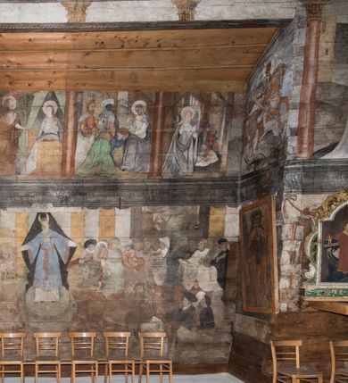 Zdjęcie nr 46: Polichromia ścienna obiegająca całe wnętrze świątyni wraz ze stropem, na ścianach kompozycje dwustrefowe. Strefy odgraniczone malowanym, profilowanym szarym cokołem z konsolami oraz umieszczonymi między nimi napisami. Na osi konsol, w drugiej strefie kolumny oddzielające poszczególne sceny. Kolumny ustawione na złoconych bazach, trzony malowane na czerwono, kapitele stylizowane na korynckie. Podpory podtrzymują malowany szary fryz zdobiony maskami, uskrzydlonymi główkami anielskimi oraz liśćmi wawrzynu.

Ściana północna nawy
W dolnej strefie znajduje się przedstawienie, tzw. Sąd Krwi, odbywający się w pałacu Kajfasza. Pośrodku sceny stoi Kajfasz na podwyższeniu ubrany w strój kapłana żydowskiego, na tle czarnej kotary. U góry napis cześciowo nieczytelny: „SAIPHAS / PONTIFEX / (?) OMNES QVID VELATIS PRAESTAT MNV(?) MORI QVAM / (?) VNIVE SV(?) POPULV (?) DE (?)RE”. Po prawej stronie kompozycji siedzi na kamiennym podeście Chrystus zwrócony trzy czwarte w prawo. Ubrany jest w czerwoną suknię, na głowie ma założoną koronę cierniową, a wokół niej kolisty nimb. Po obu stronach Kajfasza znajdują się liczni członkowie Sanhedrynu, którzy trzymają w dłoniach zwoje z ich imionami oraz orzeczeniami winy, część z nich jest nieczytelna: „INCOGNITA CAV/SA MORTI OBU(?)/EN BVS”, „(?) / ROGAT / NOR(?)M (?) / HIC (?)OMC PE(?)A /VIT”, „PAD / (?)EDV(?) / (?)T / (?)N”, „(?)SMO(?) / (?)HIN (?)”, „RIPHA(?) / LEX IN (?)”, „QRAM / QVARE SINE/MVS VIRVM / (?) QVIA / IVSTVS EST / MORTE DAM(?)”, „EM / IVSTVS / MAXIME QVV / POPVLVM SV(?) / CONCIONIRVS / (?)IONEM / (?)ONC(?)”, „NECODE / (?)CEM ACC(?) / PVLV SEDVCD / MORTE DIGNUS(?) /EST”, „(?)TRIE / (?)NITIE”, „MES / SI(?)VSTVS / EST CONVER / (?)AMVR ADI/(?)VM SINE / (?)VST (?)”, „SAMEOH / SI NEC IV/STVS EST NEC / INIVSTVS Q (?)/TAMEN MO(?)/MVR: C(?) / NON CI (?) /MORTE / EL EXILI / O IPSV / DAMNA/MVS”. Ponadto zachowane pojedyncze litery w dolnej części sceny oraz fragmenty długiego napisu po prawej u góry: „(?) CRV(?) (…) NOS / ET SVP(?)R FILIOS”. W górnej strefie od lewej strony pierwsza kwatera nieczytelna. W drugiej znajduje się scena ukazująca Chrystusa Zmartwychwstałego odwiedzającego Matkę Boską. Poniżej w partii cokołu napis: „T(?) ITA EVIT SVBIIT TAMEN A SPERA MORIS / N(?)LA SED STRATA MORTE RESVRGIT”. W drugiej kwaterze Pokłon Trzech Króli, opatrzony napisem: „CURVATO REGES VENER NTVR POPLITE REGEM / REGYM. NEC MIRUMOIVS DOCET OFFICIVM”. W ostatniej scena ukazująca Boże Narodzenie z podpisem: „VIRGO (?)NTIVSI(?)E P(?)VOD DINERAT ANTE / JAM(?) NIS PALPAS UPERE NVI S. ANAS”.

Ściana łuku arkady tęczowej
Po stronie północnej – dolna strefa nieczytelna, w górnej przedstawienie św. Jerzego na koniu walczącego ze smokiem. Po stronie południowej arkady tęczowej w górnej strefie św. Marcin ucinający połę swojego płaszcza dla żebraka. 

Prezbiterium
Na ścianie północnej lewa strona strefy dolnej niezachowana, dalej drzwi do zakrystii flankowane parą kolumn o czarnych trzonach i korynckich kapitelach. W nadprożu scena ukazująca Chrystusa Zmartwychwstałego Triumfującego, który jedzie na zaprzężonym w trzy baranki powozie. Na tyle pojazdu leżą narzędzia Męki Pańskiej. W prawym górnym narożu sceny napis: „IESVS TRIVMPHANS”. Kolejna scena przedstawia dwie święte niewiasty oraz ucztę. Scena w najnowszej literaturze interpretowana jest jako usługiwanie św. Elżbiety ubogim i chorym. W górnej strefie od lewej strony zostały ukazane następujące przedstawienia i podpisy: Nawiedzenie Najświętszej Marii Panny opisane słowami: „VISITAT ELEGTA IN GENITRICEM VIRCO TONANTIS / MA(?) (?)OMINIS PVRI VERA PARENS OVE DEI”. Kolejna scena przedstawia Zwiastowanie Najświętszej Marii Pannie: „TER QVE QVATER Q3 BEATA, ES VIRGO TE FORE MATRE / ANGELVS A CAELO DETONAT ORE DEI”. Następna kwatera ukazuje Matkę Boską Niepokalanie Poczętą. Po jej bokach znajdują się dwa anioły unoszące białe banderole z napisami: „FIA(?)MINA PLVENS CAELLS EST SVME GRATIA REGIS / A TE QVA RERIT VIRGO SIGMA (?)” oraz „CVMBA NATAT SVPIRI MARE. SED NON FLVC T. FRGO / MVNDANI FLCTIS NON TIM(?)”. W narożach symbole Litanii Loretańskiej w medalionach opisane kolejno słowami: „PER HAEC PRAESERVOR”, „FLVCTVS NON VEREOR”, „EXSPINIS SINE SPINIS ORIOR” oraz „(?)AVDOR NOCTI / LVCI APERIOR”. Poniżej sceny słabo czytelny napis: „INSIDIABARIS MALEDICTE VENENIGER ANGVIS / HV(?) (?)ENERI FAVCIBVS I GNIVS ME / (?) MVLIEREM DIRE (?)RANE / (?)PSE KIECAEM”. Poniżej przedstawienia, w partii cokołu napis: „ECCE ENIM EX HOC BEATAM ME / DICENT OMNES GENERATIONES”. W kolejnej kwaterze św. Elżbieta Węgierska i inskrypcja na cokole: „ARE ODIVA ELIZABETH: NAM TVA CLARENT / RIO MORES NOMINA FACTA POLO”.  Dalej św. Stanisław Biskup: „DIVE STANISLAE HIC MVLT LOCVS AMBIT ET OBTAT / SIS PATER ELIZABETH PATRONA SI(?)”. W części środkowej apsydy dolna cześć niezachowana, w górnej przedstawienie Mojżesza oraz Aarona. Na ścianie południowej prezbiterium w strefie dolnej ukazani kolejno czterej ojcowie Kościoła, opisani: św. Augustyn „S(ANCTVS) AVGVSTINVS”, św. Hieronim „S(ANCTVS) HIER(ONIM)”, św. Grzegorz Wielki „S(ANCTVS) GREGORIVS” oraz św. Ambroży. W strefie górnej, od lewej: św. Jan Kanty. W partii cokołowej napis: „(?) HIC EST quo PATRIARHA ACADEMIA GAVDET / (?)qucm Felic aedicai Astricolam / (?)arior hospes ades Canti no us oris / hic habites oni Alumnus Armans”. W kolejnej kwaterze ukazani są św. Piotr oraz św. Andrzej: „CREDO IN DEVM PATREM OMNIPOTENTE CREATORE CA(?)ETERE ET IN IESVM CHRI/STVM FILIVM (?)VS VNICVM DOMINVM / NOSTRVM”. Następnie św. Bartłomiej i św. Filip: „DESCENDIT AD INFEROS, TERTIA DIE RESVB / REXIT AMORTVIS ASCENDIT, AD CAELOS SEDENT, A DEXTERAM DEI PATRIS OMNI: / POTENTIS”. W ostatniej kwaterze prezbiterium ukazani są św. Tomasz oraz drugi, nierozpoznany apostoł: „CREDO IN SPIRITVM / SANCTVM”.

Ściana północna nawy
Polichromia na ścianie północnej częściowo niezachowana. W dolnej strefie scena ukazująca Modlitwę w Ogrójcu oraz narzędzia Męki Pańskiej: „(?)S SALVATOR / M(?)”. W górnej strefie kolejni dwaj apostołowie: św. Szymon i św. Juda Tadeusz: „SANCTA(?) / MVNION (?)”. Kolejna kwatera nieczytelna.

Balustrada chóru muzycznego
Balustradę chóru muzycznego zdobią alegorie siedmiu grzechów głównych pod postacią kobiet i towarzyszących im atrybutów, pierwsza z lewej Pycha, następna Chciwość, kolejne nieczytelne. Pod chórem muzycznym uskrzydlona główka aniołka nad portalem wejściowym, a po prawej stronie napis: „SPECVLVM / (?) MAI(?) OMNIB(?) VI(?)SIM(?) (?) CADENTI V RESCAT / (?)”.

Strop
Kompozycja stropu podzielona na trzy strefy, dwie duże boczne oraz wąską, środkową. W pierwszej strefie bocznej umieszczona jest rozbudowana kompozycja przedstawiająca Wniebowzięcie Najświętszej Marii Panny. W dolnej strefie pusty grób oraz apostołowie. Matkę Boską otaczają grupy muzykujących aniołów, u góry stoi Chrystus. W strefie środkowej ukazana została Koronacja Matki Boskiej, a w drugiej strefie bocznej Sąd Ostateczny. Partia malowideł na stropie również dookoła opatrzona jest napisami, lecz nieczytelnymi. 
