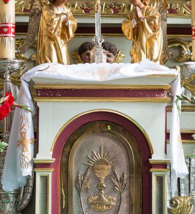 Zdjęcie nr 32: Ołtarz drewniany, prostopadłościenny, mensa drewniana z kamiennym portatylem. Antependium drewniane, na profilowanym cokole, ujęte parą lizen z  płycinami w kształcie stojących prostokątów, zamkniętych półkoliście podtrzymujących gzyms; w polu obraz w formie leżącego prostokąta z obrazem Ostatnia Wieczerza malowanym olejno na desce. Tabernakulum w formie drewnianej skrzynki; na ścianie frontowej arkada, której łuk opiera się na parze pilastrów z płycinami na trzonach, flankujących drzwiczki; całość zamknięta profilowanym gzymsem. Fakturowane drzwiczki w formie stojącego prostokąta zamkniętego łukiem półkolistym z aplikowanymi kielichem z Hostią w glorii, ujętym kłosami zbóż i kiściami winogron. Na tabernakulum dwie klęczące figurki modlących się aniołów i krucyfiks. 

Nastawa ołtarzowa architektoniczna, jednoosiowa, jednokondygnacyjna ze zwieńczeniem i bramkami. Na dwustrefowym cokole o zryzalitowanych brzegach ustawiona jest nastawa. Kondygnacja ujęta parą kolumn o kapitelach kompozytowych i skręconych trzonach, stojących na ukośnie ustawionych cokołach. Podpory dźwigają pełne belkowanie, przerwane nad polem środkowym. W polu podwójna nisza, każda ujęta ramą w formie stojącego prostokąta zamkniętego łukiem nadwieszonym. Wewnątrz rzeźba św. Elżbiety Węgierskiej. Po bokach nastawy ustawione dwie figury świętych królewiczów węgierskich. Kondygnacja ujęta uszami utworzonymi z liści akantu i karbowanej wstęgi.

Zwieńczenie w formie zbliżonej do trójkąta, ujęte spływami wolutowymi, zamknięte falowanym gzymsem przyjmującym trójkątny kształt, zakończone glorią promienistą z rzeźbą Boga Ojca. W polu zwieńczenia wspornik ze stojącą figurką Matki Boskiej na tle glorii i obłoków, pośród rzeźbionych uskrzydlonych główek anielskich i pary aniołków. Po bokach zwieńczenia ustawione dwie figury świętych niewiast.

Bramki w formie podwieszonych łuków nadwieszonych. Przejście zamknięte łukiem wklęsło-wypukłym z uskokami. Na bramkach ustawione są figury: po lewej stronie św. Piotra, a po prawej św. Pawła.

Cokoły, bramki, pole środkowe i fryz dekorowane akantem. Skręcone trzony kolumn dekorowane wicią roślinną. Struktura polichromowana w kolorze beżowym z czerwonymi profilami; ornamentyka i profile złocone; detale i trzony kolumn srebrzone. 

Na boku ołtarza tabliczka: „FUNDACJA / ZŁOCENIA OŁTARZA GŁÓWNEGO /  KOŁO NR 1 / PRZY ZWIĄZKU SPISZA / CHICAGO / U. S. A. / 2003 R.”. 