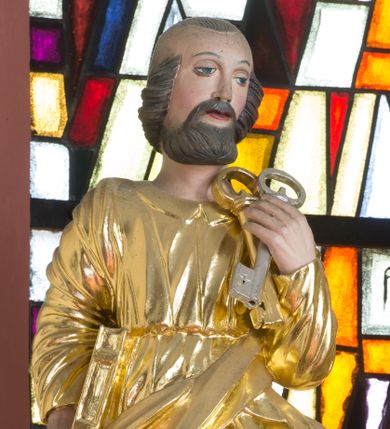 Zdjęcie nr 1: Rzeźba przedstawia św. Piotra, ustawionego na półkolistym, srebrzonym cokole. Święty ukazany frontalnie, w lewej dłoni uniesionej na wysokości barku trzyma dwa klucze, a w prawej przy boku trzyma księgę. Twarz pełna o delikatnie rozchylonych ustach i dużych oczach. Głowa okolona krótką brodą oraz włosami po bokach głowy i kępką na jej czubku. Święty ubrany jest w długą suknię, przewiązaną w talii oraz złocony płaszcz przechodzący ukośnie z przodu i pod lewą ręką. Draperia szat miękka o równoległych fałdach; dłonie wyrzeźbione sztywno i niedbale. Polichromia w odsłoniętych partiach ciała naturalistyczna, szaty i atrybuty złocone oraz srebrzone.
