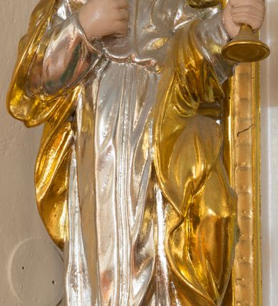 Zdjęcie nr 7: Ołtarz architektoniczny, dwukondygnacyjny, jednoosiowy ze zwieńczeniem. Ołtarz prostopadłościenny z drewnianą mensą i kamiennym portatylem. Antependium ozdobione trzema płycinami z czego środkowa w kształcie czwórliścia przenikającego się z kwadratem; dwie boczne, ustawione antytetycznie, w kształcie leżącego prostokąta z parą boków wewnętrznych w kształcie łuku nadwieszonego wklęsłego. W płycinie środkowej polichromowany monogram maryjny, w płycinach bocznych po lewej stronie Zwiastowanie, a po prawej Ucieczka do Egiptu. 

Nastawa na niewysokim, uskokowym cokole o ukośnie ustawionych bokach, zdobionych słonecznikami. W środkowej partii cokołu wkomponowane tabernakulum w formie prostopadłościennej szafki na profilowanym, uskokowym cokole z narożami ujętymi dwoma parami pilastrów z półwałkiem pośrodku trzonu, wspierających profilowany, uskokowy gzyms. Drzwiczki tabernakulum w kształcie prostokąta zamkniętego łukiem półkolistym, w polu płaskorzeźbiony kielich z Hostią oraz kłosami zbóż. Kondygnacja flankowana parą zdwojonych pilastrów oraz dostawionych, ustawionych pod kątem pilastrów z nałożonymi spływami wolutowymi. Podpory wspierają przerywane, niepełne belkowanie oraz przyczółek. Pole środkowe zajmuje wnęka w kształcie stojącego prostokąta, zamkniętego półkoliście. W polu figura Matki Boskiej Niepokalanie Poczętej. Pod wnęką podwieszona, rzeźbiona girlanda. Po lewej stronie kondygnacji, na cokole ułożonym na zakończeniu woluty ustawiona jest rzeźba św. Jana Ewangelisty, a po drugiej stronie figura nierozpoznanej świętej. Na belkowaniu usadzona jest para aniołków. Druga kondygnacja w formie wnęki w kształcie stojącego prostokąta, zamkniętego półkoliście, flankowana po bokach filarami, ozdobionymi liśćmi akantu. W polu umieszczona rzeźba św. Mikołaja. Nad rzeźbą stylizowana duża muszla palmetowa z podwieszonymi liśćmi akantu. Zwieńczenie w formie promienistej glorii z Okiem Opatrzności pośrodku, ujętej wieńcem srebrzonych obłoków. Struktura polichromowana na biało, detal architektoniczny i ornamentyka złocone oraz srebrzone. Na cokole tabliczka z napisem: „FUNDACJA / SREBRZENIE ŚWIECZNIKÓW / OŁTARZA NMP / Franciszek i Małgorzata Łojek / 2003”. 