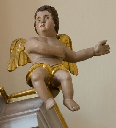 Zdjęcie nr 15: Ołtarz architektoniczny, dwukondygnacyjny, jednoosiowy ze zwieńczeniem. Ołtarz prostopadłościenny z drewnianą mensą i kamiennym portatylem. Antependium ozdobione trzema płycinami z czego środkowa w kształcie czwórliścia przenikającego się z kwadratem; dwie boczne, ustawione antytetycznie, w kształcie leżącego prostokąta z parą boków wewnętrznych w kształcie łuku nadwieszonego wklęsłego. W płycinie środkowej polichromowany monogram maryjny, w płycinach bocznych po lewej stronie Zwiastowanie, a po prawej Ucieczka do Egiptu. 

Nastawa na niewysokim, uskokowym cokole o ukośnie ustawionych bokach, zdobionych słonecznikami. W środkowej partii cokołu wkomponowane tabernakulum w formie prostopadłościennej szafki na profilowanym, uskokowym cokole z narożami ujętymi dwoma parami pilastrów z półwałkiem pośrodku trzonu, wspierających profilowany, uskokowy gzyms. Drzwiczki tabernakulum w kształcie prostokąta zamkniętego łukiem półkolistym, w polu płaskorzeźbiony kielich z Hostią oraz kłosami zbóż. Kondygnacja flankowana parą zdwojonych pilastrów oraz dostawionych, ustawionych pod kątem pilastrów z nałożonymi spływami wolutowymi. Podpory wspierają przerywane, niepełne belkowanie oraz przyczółek. Pole środkowe zajmuje wnęka w kształcie stojącego prostokąta, zamkniętego półkoliście. W polu figura Matki Boskiej Niepokalanie Poczętej. Pod wnęką podwieszona, rzeźbiona girlanda. Po lewej stronie kondygnacji, na cokole ułożonym na zakończeniu woluty ustawiona jest rzeźba św. Jana Ewangelisty, a po drugiej stronie figura nierozpoznanej świętej. Na belkowaniu usadzona jest para aniołków. Druga kondygnacja w formie wnęki w kształcie stojącego prostokąta, zamkniętego półkoliście, flankowana po bokach filarami, ozdobionymi liśćmi akantu. W polu umieszczona rzeźba św. Mikołaja. Nad rzeźbą stylizowana duża muszla palmetowa z podwieszonymi liśćmi akantu. Zwieńczenie w formie promienistej glorii z Okiem Opatrzności pośrodku, ujętej wieńcem srebrzonych obłoków. Struktura polichromowana na biało, detal architektoniczny i ornamentyka złocone oraz srebrzone. Na cokole tabliczka z napisem: „FUNDACJA / SREBRZENIE ŚWIECZNIKÓW / OŁTARZA NMP / Franciszek i Małgorzata Łojek / 2003”. 