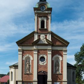 Zdjęcie nr 1: Kościół murowany, jednonawowy, z węższym prezbiterium zamkniętym trójbocznie oraz z wieżą wbudowaną w zachodnią fasadę. Do prezbiterium od północy przylega zakrystia, do nawy dwie kaplice leżące po przeciwległych stronach, zamknięte trójbocznie, od zachodu chór wsparty na dwóch filarach, z trójczęściową balustradą wychodzącą do przodu. Korpus trójprzęsłowy, przęsła oddzielone opilastrowanymi filarami podtrzymującymi arkady sklepienia. Nad kaplicami i prezbiterium fragmenty sklepienia gwiaździstego, nad nawą żaglaste. Wielobarwna polichromia  ścian i sklepień wypełnia podziały wyznaczone przez elementy architektoniczne, opiera się na motywach geometrycznych, stylizowanych floralnych, zoomorficznych i postaciach aniołów i świętych . Wszystkie okna w kształcie stojącego prostokąta zamkniętego półkoliście, w większości witraże, dwa w prezbiterium, po trzy z każdej strony nawy, po dwa w kaplicach, dwa na wysokości chóru, cztery w kondygnacji wieży; wyjątek stanowi okulus w fasadzie. Główne wejście przez fasadę, kolejne do zakrystii. Fasada dwukondygnacyjna, trójosiowa, na cokole, z wieżą. Osie wydzielone pilastrami, z których środkowa mieści drzwi o wykroju prostokąta i okulus w czworobocznej płycinie, a boczne zamknięte konchowo nisze w figurami św. Piotra po lewej i św. Pawła po prawej stronie. Kondygnacja zamknięta zdwojonym przyczółkiem. Wewnętrzny przerwany na kartusz herbowy i okrągłą plakietę z krzyżem, zewnętrzny na kondygnację wieży.  Wieża z każdej strony przepruta oknem zwieńczonym fragmentem gzymsu, na narożach ujęta pilastrami podtrzymującymi belkowanie z linią gzymsu wyoblającą się w środku i ujmującą tarczę zegara. Pozostałe elewacje na kamiennym cokole, nawa i prezbiterium z nietynkowanej cegły, kaplice i zakrystia otynkowane. Kontynuują podziały  pilastrami, artykulację podkreślają okna.  Dach nad nawą główną dwuspadowy, nad kaplicami i prezbiterium wieloboczne, wieża przekryta hełmem z latarnią, zwieńczona ostrosłupem z krzyżem.  
Najcenniejszym zabytkiem świątyni jest ołtarz główny z około 1700 roku przeniesiony tutaj z kościoła z Limanowej, interesująca jest polichromia o inspiracjach młodopolskich z elementami art  decó. 
