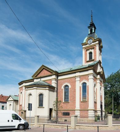 Zdjęcie nr 36: Kościół murowany, jednonawowy, z węższym prezbiterium zamkniętym trójbocznie oraz z wieżą wbudowaną w zachodnią fasadę. Do prezbiterium od północy przylega zakrystia, do nawy dwie kaplice leżące po przeciwległych stronach, zamknięte trójbocznie, od zachodu chór wsparty na dwóch filarach, z trójczęściową balustradą wychodzącą do przodu. Korpus trójprzęsłowy, przęsła oddzielone opilastrowanymi filarami podtrzymującymi arkady sklepienia. Nad kaplicami i prezbiterium fragmenty sklepienia gwiaździstego, nad nawą żaglaste. Wielobarwna polichromia  ścian i sklepień wypełnia podziały wyznaczone przez elementy architektoniczne, opiera się na motywach geometrycznych, stylizowanych floralnych, zoomorficznych i postaciach aniołów i świętych . Wszystkie okna w kształcie stojącego prostokąta zamkniętego półkoliście, w większości witraże, dwa w prezbiterium, po trzy z każdej strony nawy, po dwa w kaplicach, dwa na wysokości chóru, cztery w kondygnacji wieży; wyjątek stanowi okulus w fasadzie. Główne wejście przez fasadę, kolejne do zakrystii. Fasada dwukondygnacyjna, trójosiowa, na cokole, z wieżą. Osie wydzielone pilastrami, z których środkowa mieści drzwi o wykroju prostokąta i okulus w czworobocznej płycinie, a boczne zamknięte konchowo nisze w figurami św. Piotra po lewej i św. Pawła po prawej stronie. Kondygnacja zamknięta zdwojonym przyczółkiem. Wewnętrzny przerwany na kartusz herbowy i okrągłą plakietę z krzyżem, zewnętrzny na kondygnację wieży.  Wieża z każdej strony przepruta oknem zwieńczonym fragmentem gzymsu, na narożach ujęta pilastrami podtrzymującymi belkowanie z linią gzymsu wyoblającą się w środku i ujmującą tarczę zegara. Pozostałe elewacje na kamiennym cokole, nawa i prezbiterium z nietynkowanej cegły, kaplice i zakrystia otynkowane. Kontynuują podziały  pilastrami, artykulację podkreślają okna.  Dach nad nawą główną dwuspadowy, nad kaplicami i prezbiterium wieloboczne, wieża przekryta hełmem z latarnią, zwieńczona ostrosłupem z krzyżem.  
Najcenniejszym zabytkiem świątyni jest ołtarz główny z około 1700 roku przeniesiony tutaj z kościoła z Limanowej, interesująca jest polichromia o inspiracjach młodopolskich z elementami art  decó. 
