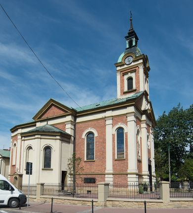 Zdjęcie nr 35: Kościół murowany, jednonawowy, z węższym prezbiterium zamkniętym trójbocznie oraz z wieżą wbudowaną w zachodnią fasadę. Do prezbiterium od północy przylega zakrystia, do nawy dwie kaplice leżące po przeciwległych stronach, zamknięte trójbocznie, od zachodu chór wsparty na dwóch filarach, z trójczęściową balustradą wychodzącą do przodu. Korpus trójprzęsłowy, przęsła oddzielone opilastrowanymi filarami podtrzymującymi arkady sklepienia. Nad kaplicami i prezbiterium fragmenty sklepienia gwiaździstego, nad nawą żaglaste. Wielobarwna polichromia  ścian i sklepień wypełnia podziały wyznaczone przez elementy architektoniczne, opiera się na motywach geometrycznych, stylizowanych floralnych, zoomorficznych i postaciach aniołów i świętych . Wszystkie okna w kształcie stojącego prostokąta zamkniętego półkoliście, w większości witraże, dwa w prezbiterium, po trzy z każdej strony nawy, po dwa w kaplicach, dwa na wysokości chóru, cztery w kondygnacji wieży; wyjątek stanowi okulus w fasadzie. Główne wejście przez fasadę, kolejne do zakrystii. Fasada dwukondygnacyjna, trójosiowa, na cokole, z wieżą. Osie wydzielone pilastrami, z których środkowa mieści drzwi o wykroju prostokąta i okulus w czworobocznej płycinie, a boczne zamknięte konchowo nisze w figurami św. Piotra po lewej i św. Pawła po prawej stronie. Kondygnacja zamknięta zdwojonym przyczółkiem. Wewnętrzny przerwany na kartusz herbowy i okrągłą plakietę z krzyżem, zewnętrzny na kondygnację wieży.  Wieża z każdej strony przepruta oknem zwieńczonym fragmentem gzymsu, na narożach ujęta pilastrami podtrzymującymi belkowanie z linią gzymsu wyoblającą się w środku i ujmującą tarczę zegara. Pozostałe elewacje na kamiennym cokole, nawa i prezbiterium z nietynkowanej cegły, kaplice i zakrystia otynkowane. Kontynuują podziały  pilastrami, artykulację podkreślają okna.  Dach nad nawą główną dwuspadowy, nad kaplicami i prezbiterium wieloboczne, wieża przekryta hełmem z latarnią, zwieńczona ostrosłupem z krzyżem.  
Najcenniejszym zabytkiem świątyni jest ołtarz główny z około 1700 roku przeniesiony tutaj z kościoła z Limanowej, interesująca jest polichromia o inspiracjach młodopolskich z elementami art  decó. 
