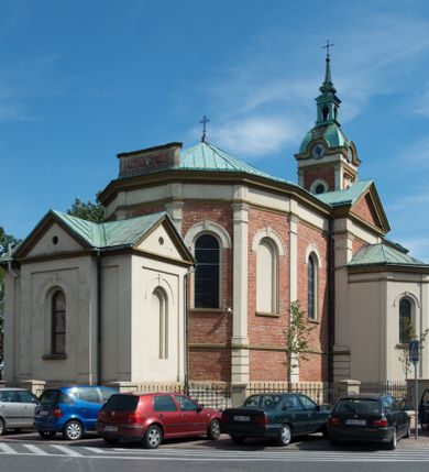 Zdjęcie nr 7: Kościół murowany, jednonawowy, z węższym prezbiterium zamkniętym trójbocznie oraz z wieżą wbudowaną w zachodnią fasadę. Do prezbiterium od północy przylega zakrystia, do nawy dwie kaplice leżące po przeciwległych stronach, zamknięte trójbocznie, od zachodu chór wsparty na dwóch filarach, z trójczęściową balustradą wychodzącą do przodu. Korpus trójprzęsłowy, przęsła oddzielone opilastrowanymi filarami podtrzymującymi arkady sklepienia. Nad kaplicami i prezbiterium fragmenty sklepienia gwiaździstego, nad nawą żaglaste. Wielobarwna polichromia  ścian i sklepień wypełnia podziały wyznaczone przez elementy architektoniczne, opiera się na motywach geometrycznych, stylizowanych floralnych, zoomorficznych i postaciach aniołów i świętych . Wszystkie okna w kształcie stojącego prostokąta zamkniętego półkoliście, w większości witraże, dwa w prezbiterium, po trzy z każdej strony nawy, po dwa w kaplicach, dwa na wysokości chóru, cztery w kondygnacji wieży; wyjątek stanowi okulus w fasadzie. Główne wejście przez fasadę, kolejne do zakrystii. Fasada dwukondygnacyjna, trójosiowa, na cokole, z wieżą. Osie wydzielone pilastrami, z których środkowa mieści drzwi o wykroju prostokąta i okulus w czworobocznej płycinie, a boczne zamknięte konchowo nisze w figurami św. Piotra po lewej i św. Pawła po prawej stronie. Kondygnacja zamknięta zdwojonym przyczółkiem. Wewnętrzny przerwany na kartusz herbowy i okrągłą plakietę z krzyżem, zewnętrzny na kondygnację wieży.  Wieża z każdej strony przepruta oknem zwieńczonym fragmentem gzymsu, na narożach ujęta pilastrami podtrzymującymi belkowanie z linią gzymsu wyoblającą się w środku i ujmującą tarczę zegara. Pozostałe elewacje na kamiennym cokole, nawa i prezbiterium z nietynkowanej cegły, kaplice i zakrystia otynkowane. Kontynuują podziały  pilastrami, artykulację podkreślają okna.  Dach nad nawą główną dwuspadowy, nad kaplicami i prezbiterium wieloboczne, wieża przekryta hełmem z latarnią, zwieńczona ostrosłupem z krzyżem.  
Najcenniejszym zabytkiem świątyni jest ołtarz główny z około 1700 roku przeniesiony tutaj z kościoła z Limanowej, interesująca jest polichromia o inspiracjach młodopolskich z elementami art  decó. 
