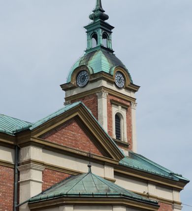 Zdjęcie nr 10: Kościół murowany, jednonawowy, z węższym prezbiterium zamkniętym trójbocznie oraz z wieżą wbudowaną w zachodnią fasadę. Do prezbiterium od północy przylega zakrystia, do nawy dwie kaplice leżące po przeciwległych stronach, zamknięte trójbocznie, od zachodu chór wsparty na dwóch filarach, z trójczęściową balustradą wychodzącą do przodu. Korpus trójprzęsłowy, przęsła oddzielone opilastrowanymi filarami podtrzymującymi arkady sklepienia. Nad kaplicami i prezbiterium fragmenty sklepienia gwiaździstego, nad nawą żaglaste. Wielobarwna polichromia  ścian i sklepień wypełnia podziały wyznaczone przez elementy architektoniczne, opiera się na motywach geometrycznych, stylizowanych floralnych, zoomorficznych i postaciach aniołów i świętych . Wszystkie okna w kształcie stojącego prostokąta zamkniętego półkoliście, w większości witraże, dwa w prezbiterium, po trzy z każdej strony nawy, po dwa w kaplicach, dwa na wysokości chóru, cztery w kondygnacji wieży; wyjątek stanowi okulus w fasadzie. Główne wejście przez fasadę, kolejne do zakrystii. Fasada dwukondygnacyjna, trójosiowa, na cokole, z wieżą. Osie wydzielone pilastrami, z których środkowa mieści drzwi o wykroju prostokąta i okulus w czworobocznej płycinie, a boczne zamknięte konchowo nisze w figurami św. Piotra po lewej i św. Pawła po prawej stronie. Kondygnacja zamknięta zdwojonym przyczółkiem. Wewnętrzny przerwany na kartusz herbowy i okrągłą plakietę z krzyżem, zewnętrzny na kondygnację wieży.  Wieża z każdej strony przepruta oknem zwieńczonym fragmentem gzymsu, na narożach ujęta pilastrami podtrzymującymi belkowanie z linią gzymsu wyoblającą się w środku i ujmującą tarczę zegara. Pozostałe elewacje na kamiennym cokole, nawa i prezbiterium z nietynkowanej cegły, kaplice i zakrystia otynkowane. Kontynuują podziały  pilastrami, artykulację podkreślają okna.  Dach nad nawą główną dwuspadowy, nad kaplicami i prezbiterium wieloboczne, wieża przekryta hełmem z latarnią, zwieńczona ostrosłupem z krzyżem.  
Najcenniejszym zabytkiem świątyni jest ołtarz główny z około 1700 roku przeniesiony tutaj z kościoła z Limanowej, interesująca jest polichromia o inspiracjach młodopolskich z elementami art  decó. 
