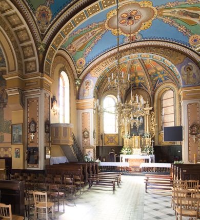 Zdjęcie nr 21: Kościół murowany, jednonawowy, z węższym prezbiterium zamkniętym trójbocznie oraz z wieżą wbudowaną w zachodnią fasadę. Do prezbiterium od północy przylega zakrystia, do nawy dwie kaplice leżące po przeciwległych stronach, zamknięte trójbocznie, od zachodu chór wsparty na dwóch filarach, z trójczęściową balustradą wychodzącą do przodu. Korpus trójprzęsłowy, przęsła oddzielone opilastrowanymi filarami podtrzymującymi arkady sklepienia. Nad kaplicami i prezbiterium fragmenty sklepienia gwiaździstego, nad nawą żaglaste. Wielobarwna polichromia  ścian i sklepień wypełnia podziały wyznaczone przez elementy architektoniczne, opiera się na motywach geometrycznych, stylizowanych floralnych, zoomorficznych i postaciach aniołów i świętych . Wszystkie okna w kształcie stojącego prostokąta zamkniętego półkoliście, w większości witraże, dwa w prezbiterium, po trzy z każdej strony nawy, po dwa w kaplicach, dwa na wysokości chóru, cztery w kondygnacji wieży; wyjątek stanowi okulus w fasadzie. Główne wejście przez fasadę, kolejne do zakrystii. Fasada dwukondygnacyjna, trójosiowa, na cokole, z wieżą. Osie wydzielone pilastrami, z których środkowa mieści drzwi o wykroju prostokąta i okulus w czworobocznej płycinie, a boczne zamknięte konchowo nisze w figurami św. Piotra po lewej i św. Pawła po prawej stronie. Kondygnacja zamknięta zdwojonym przyczółkiem. Wewnętrzny przerwany na kartusz herbowy i okrągłą plakietę z krzyżem, zewnętrzny na kondygnację wieży.  Wieża z każdej strony przepruta oknem zwieńczonym fragmentem gzymsu, na narożach ujęta pilastrami podtrzymującymi belkowanie z linią gzymsu wyoblającą się w środku i ujmującą tarczę zegara. Pozostałe elewacje na kamiennym cokole, nawa i prezbiterium z nietynkowanej cegły, kaplice i zakrystia otynkowane. Kontynuują podziały  pilastrami, artykulację podkreślają okna.  Dach nad nawą główną dwuspadowy, nad kaplicami i prezbiterium wieloboczne, wieża przekryta hełmem z latarnią, zwieńczona ostrosłupem z krzyżem.  
Najcenniejszym zabytkiem świątyni jest ołtarz główny z około 1700 roku przeniesiony tutaj z kościoła z Limanowej, interesująca jest polichromia o inspiracjach młodopolskich z elementami art  decó. 
