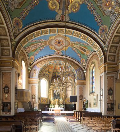 Zdjęcie nr 25: Kościół murowany, jednonawowy, z węższym prezbiterium zamkniętym trójbocznie oraz z wieżą wbudowaną w zachodnią fasadę. Do prezbiterium od północy przylega zakrystia, do nawy dwie kaplice leżące po przeciwległych stronach, zamknięte trójbocznie, od zachodu chór wsparty na dwóch filarach, z trójczęściową balustradą wychodzącą do przodu. Korpus trójprzęsłowy, przęsła oddzielone opilastrowanymi filarami podtrzymującymi arkady sklepienia. Nad kaplicami i prezbiterium fragmenty sklepienia gwiaździstego, nad nawą żaglaste. Wielobarwna polichromia  ścian i sklepień wypełnia podziały wyznaczone przez elementy architektoniczne, opiera się na motywach geometrycznych, stylizowanych floralnych, zoomorficznych i postaciach aniołów i świętych . Wszystkie okna w kształcie stojącego prostokąta zamkniętego półkoliście, w większości witraże, dwa w prezbiterium, po trzy z każdej strony nawy, po dwa w kaplicach, dwa na wysokości chóru, cztery w kondygnacji wieży; wyjątek stanowi okulus w fasadzie. Główne wejście przez fasadę, kolejne do zakrystii. Fasada dwukondygnacyjna, trójosiowa, na cokole, z wieżą. Osie wydzielone pilastrami, z których środkowa mieści drzwi o wykroju prostokąta i okulus w czworobocznej płycinie, a boczne zamknięte konchowo nisze w figurami św. Piotra po lewej i św. Pawła po prawej stronie. Kondygnacja zamknięta zdwojonym przyczółkiem. Wewnętrzny przerwany na kartusz herbowy i okrągłą plakietę z krzyżem, zewnętrzny na kondygnację wieży.  Wieża z każdej strony przepruta oknem zwieńczonym fragmentem gzymsu, na narożach ujęta pilastrami podtrzymującymi belkowanie z linią gzymsu wyoblającą się w środku i ujmującą tarczę zegara. Pozostałe elewacje na kamiennym cokole, nawa i prezbiterium z nietynkowanej cegły, kaplice i zakrystia otynkowane. Kontynuują podziały  pilastrami, artykulację podkreślają okna.  Dach nad nawą główną dwuspadowy, nad kaplicami i prezbiterium wieloboczne, wieża przekryta hełmem z latarnią, zwieńczona ostrosłupem z krzyżem.  
Najcenniejszym zabytkiem świątyni jest ołtarz główny z około 1700 roku przeniesiony tutaj z kościoła z Limanowej, interesująca jest polichromia o inspiracjach młodopolskich z elementami art  decó. 
