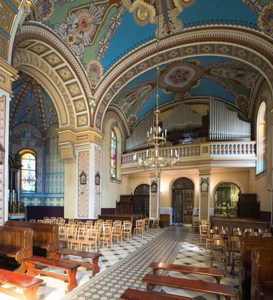 Zdjęcie nr 31: Kościół murowany, jednonawowy, z węższym prezbiterium zamkniętym trójbocznie oraz z wieżą wbudowaną w zachodnią fasadę. Do prezbiterium od północy przylega zakrystia, do nawy dwie kaplice leżące po przeciwległych stronach, zamknięte trójbocznie, od zachodu chór wsparty na dwóch filarach, z trójczęściową balustradą wychodzącą do przodu. Korpus trójprzęsłowy, przęsła oddzielone opilastrowanymi filarami podtrzymującymi arkady sklepienia. Nad kaplicami i prezbiterium fragmenty sklepienia gwiaździstego, nad nawą żaglaste. Wielobarwna polichromia  ścian i sklepień wypełnia podziały wyznaczone przez elementy architektoniczne, opiera się na motywach geometrycznych, stylizowanych floralnych, zoomorficznych i postaciach aniołów i świętych . Wszystkie okna w kształcie stojącego prostokąta zamkniętego półkoliście, w większości witraże, dwa w prezbiterium, po trzy z każdej strony nawy, po dwa w kaplicach, dwa na wysokości chóru, cztery w kondygnacji wieży; wyjątek stanowi okulus w fasadzie. Główne wejście przez fasadę, kolejne do zakrystii. Fasada dwukondygnacyjna, trójosiowa, na cokole, z wieżą. Osie wydzielone pilastrami, z których środkowa mieści drzwi o wykroju prostokąta i okulus w czworobocznej płycinie, a boczne zamknięte konchowo nisze w figurami św. Piotra po lewej i św. Pawła po prawej stronie. Kondygnacja zamknięta zdwojonym przyczółkiem. Wewnętrzny przerwany na kartusz herbowy i okrągłą plakietę z krzyżem, zewnętrzny na kondygnację wieży.  Wieża z każdej strony przepruta oknem zwieńczonym fragmentem gzymsu, na narożach ujęta pilastrami podtrzymującymi belkowanie z linią gzymsu wyoblającą się w środku i ujmującą tarczę zegara. Pozostałe elewacje na kamiennym cokole, nawa i prezbiterium z nietynkowanej cegły, kaplice i zakrystia otynkowane. Kontynuują podziały  pilastrami, artykulację podkreślają okna.  Dach nad nawą główną dwuspadowy, nad kaplicami i prezbiterium wieloboczne, wieża przekryta hełmem z latarnią, zwieńczona ostrosłupem z krzyżem.  
Najcenniejszym zabytkiem świątyni jest ołtarz główny z około 1700 roku przeniesiony tutaj z kościoła z Limanowej, interesująca jest polichromia o inspiracjach młodopolskich z elementami art  decó. 
